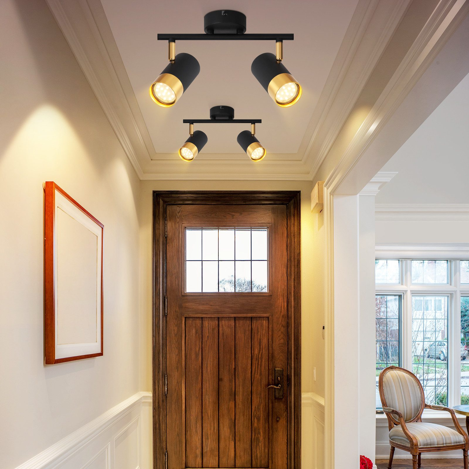 Corridoio con porta in legno, un quadro con cornice e illuminazione a binario sul soffitto.