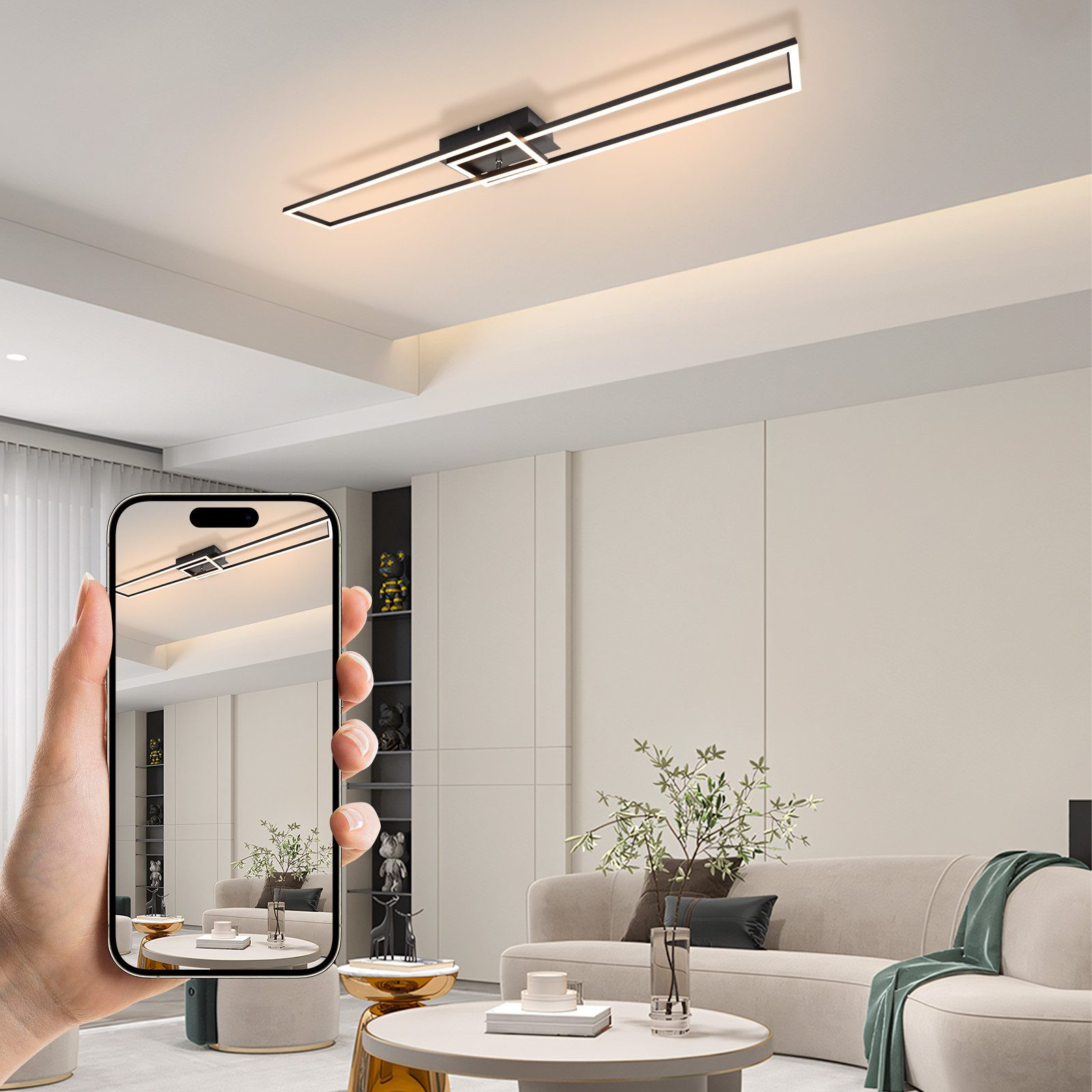 Una mano che tiene un telefono che mostra una plafoniera. La luce è nera, rettangolare e illumina un moderno soggiorno.