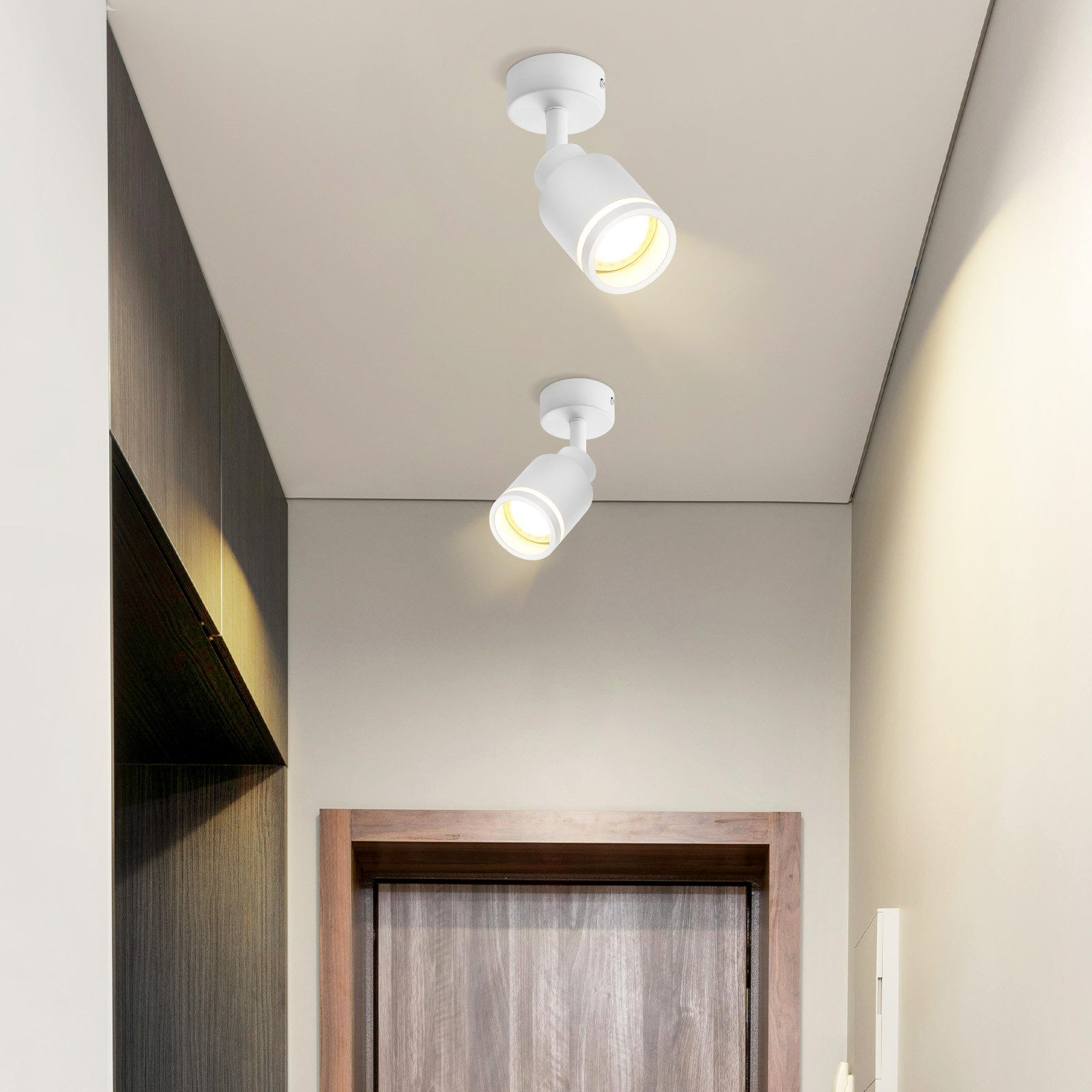 Una vista di un corridoio con due faretti bianchi sul soffitto.