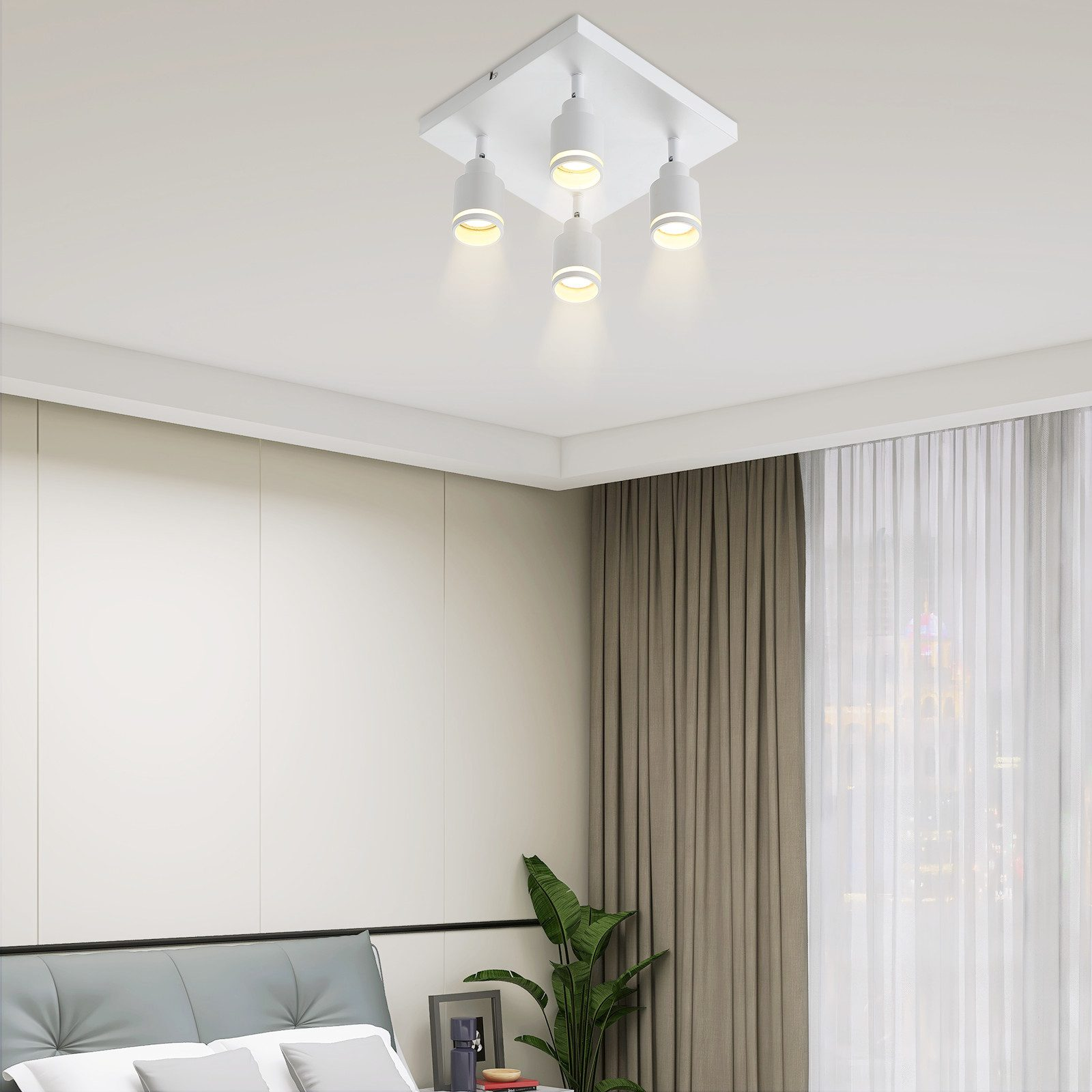 Quattro luci a incasso a soffitto illuminano una camera da letto. Le luci sono bianche e lo sfondo è una camera da letto.