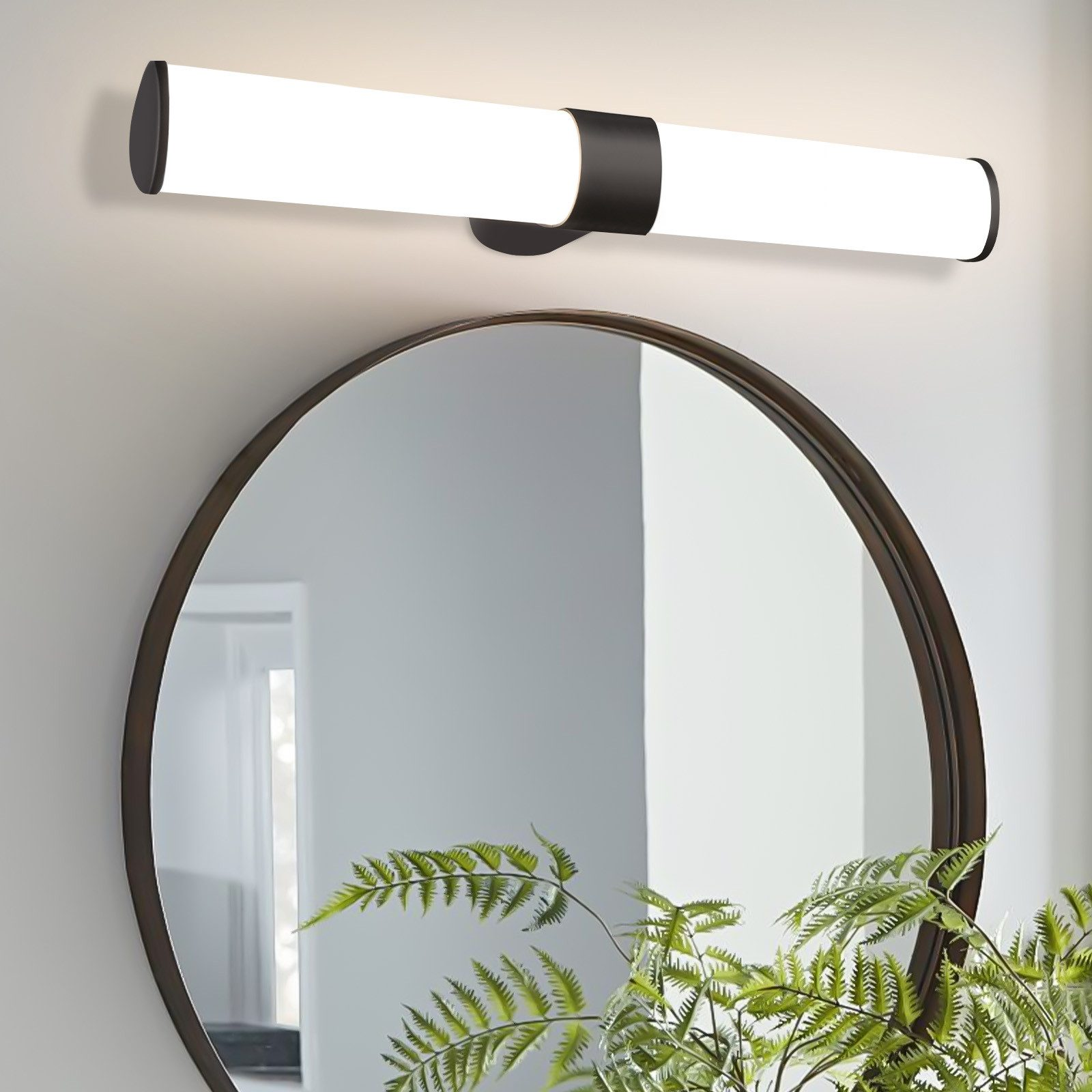 Un lungo apparecchio a LED bianco montato sopra uno specchio rotondo su una parete grigio chiaro.