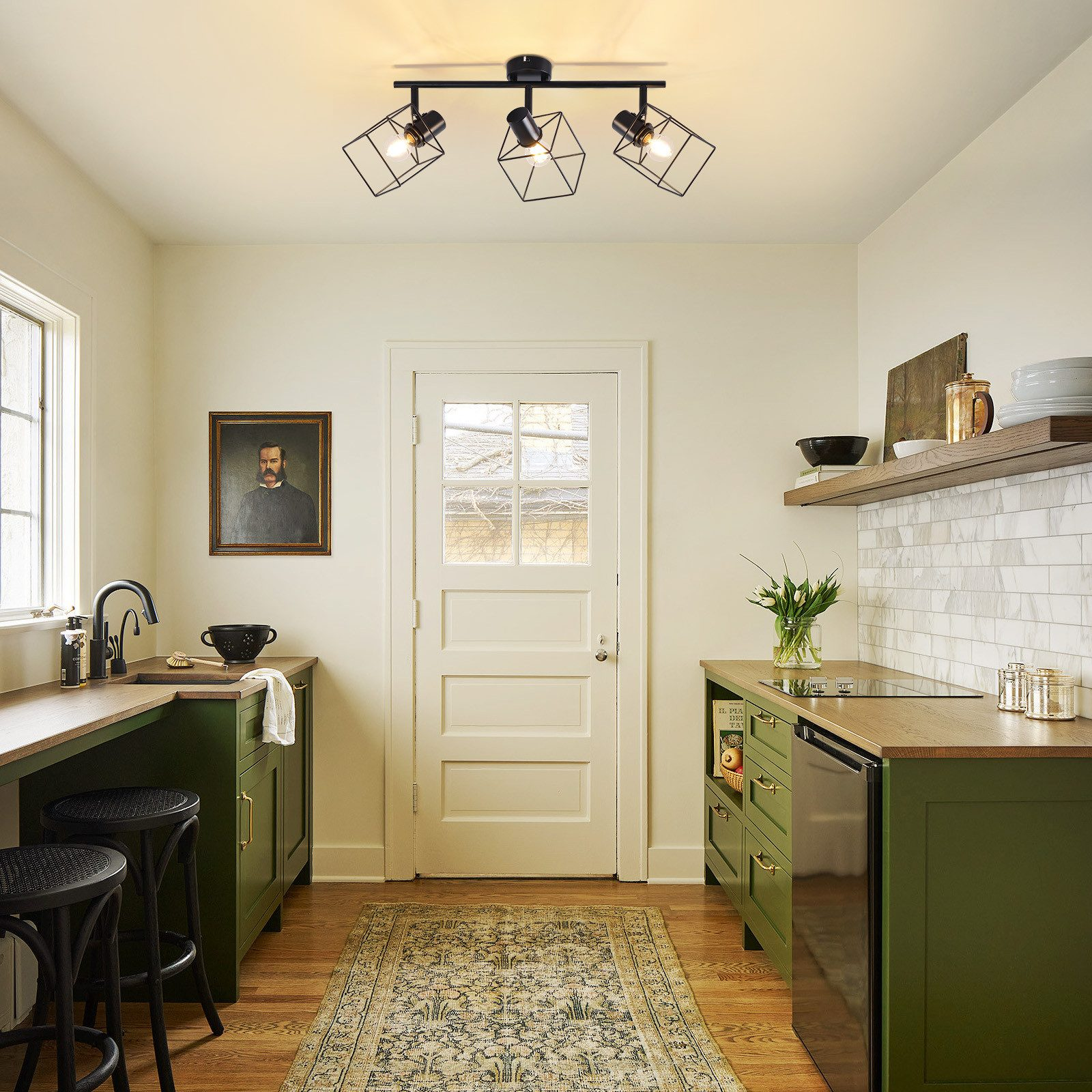 Interno cucina con design verde e bianco, con tre moderne lampade da soffitto.