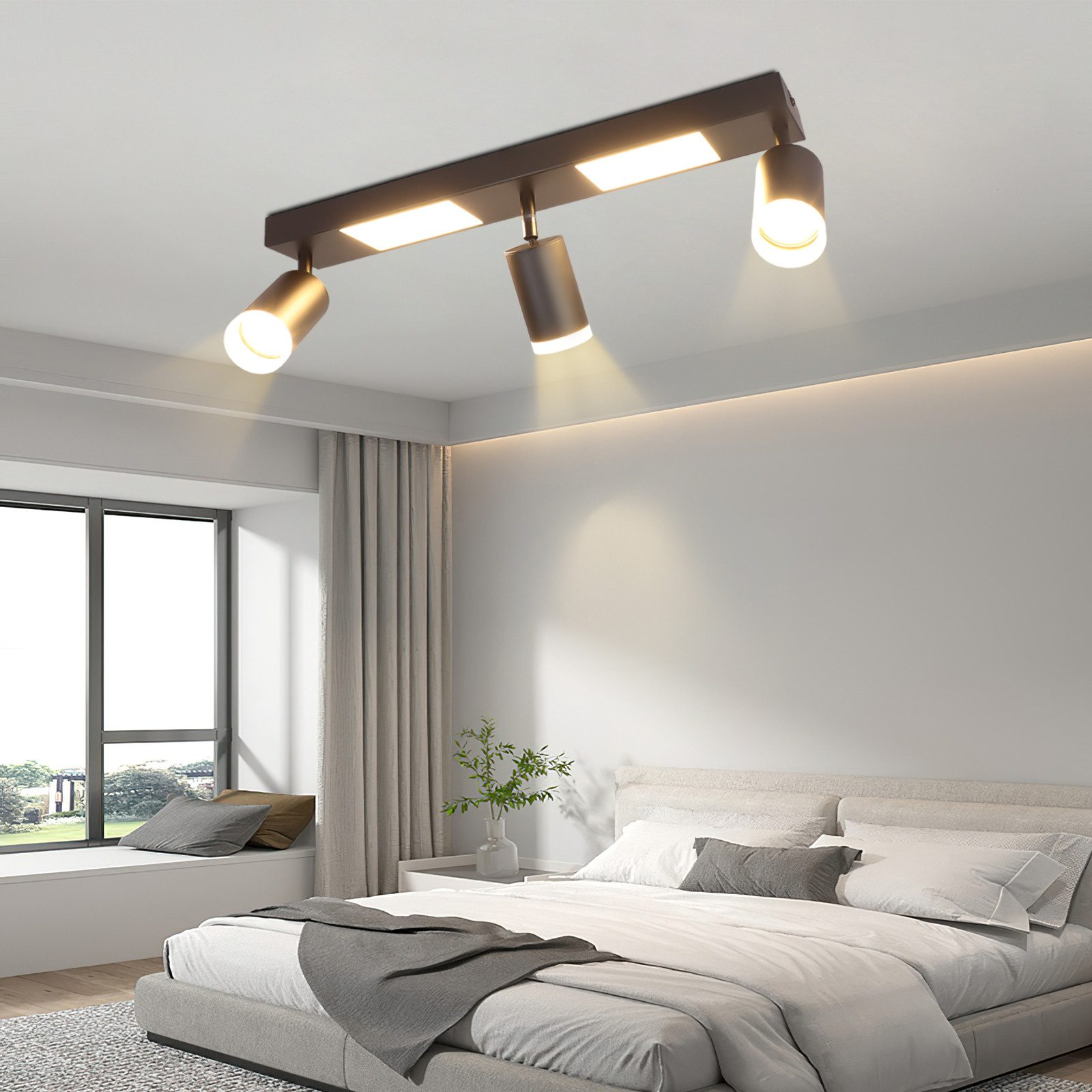 Camera da letto con faretti a binario a soffitto. Letto, finestra e tende visibili. Design moderno.