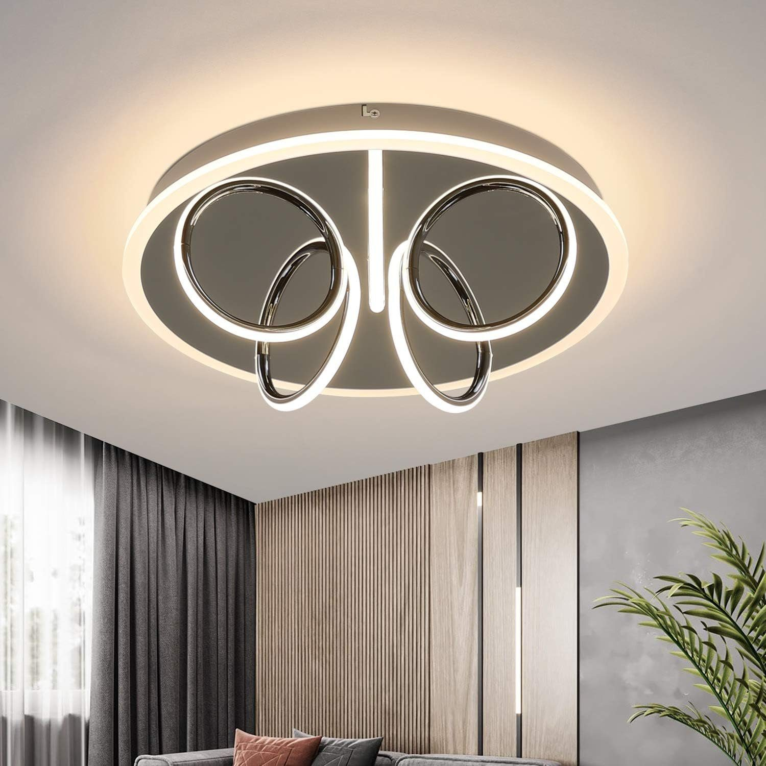 Un moderno lampada da soffitto con un design circolare. Ha elementi bianchi e argento.
