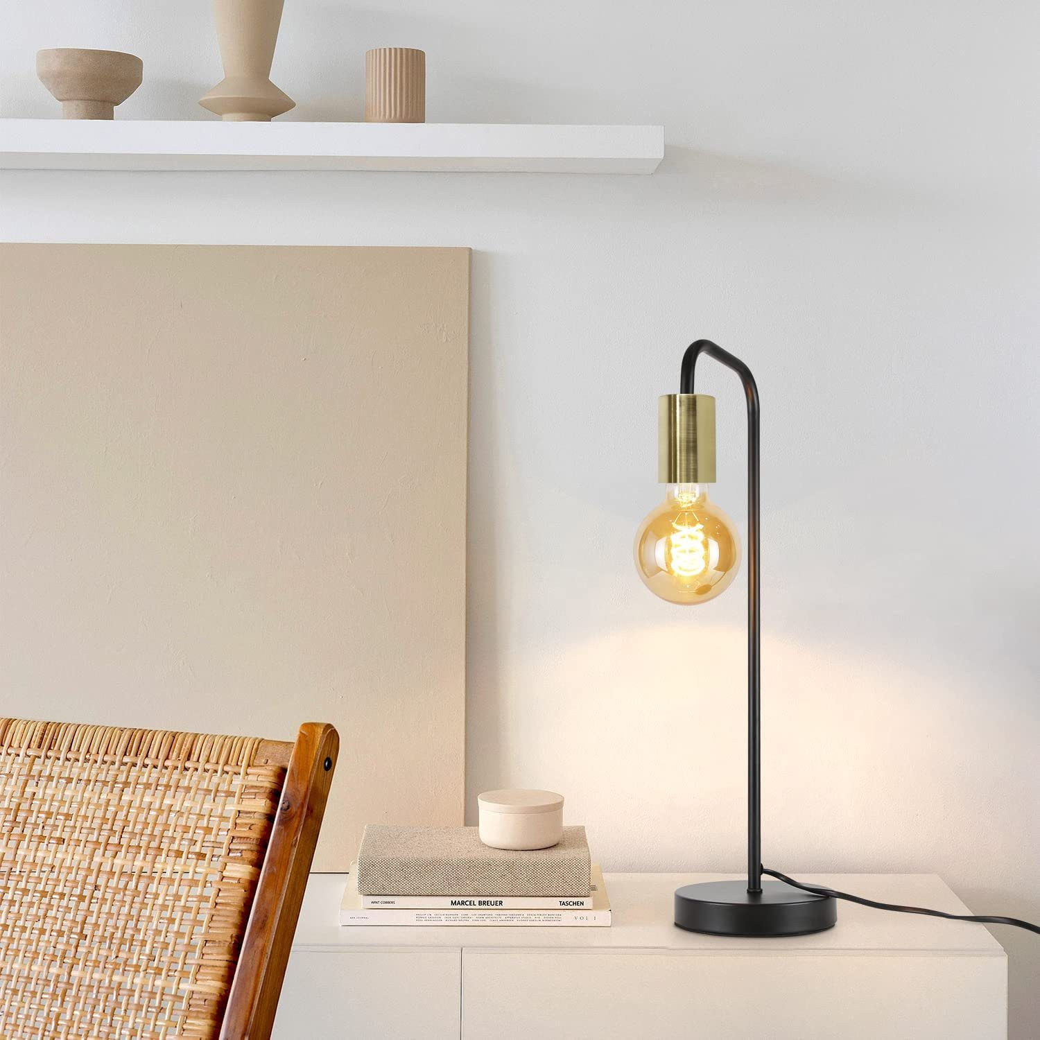 Una lampada da tavolo con la parte superiore dorata e una lampadina.