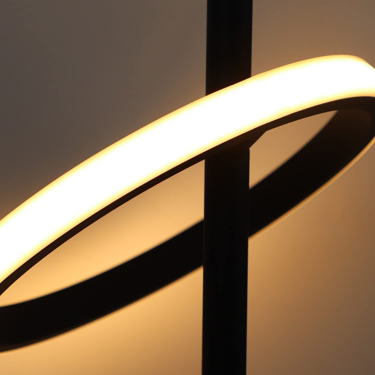 Zbliżenie na czarny słupek lampy z zakrzywionym światłem emitowanym od góry.