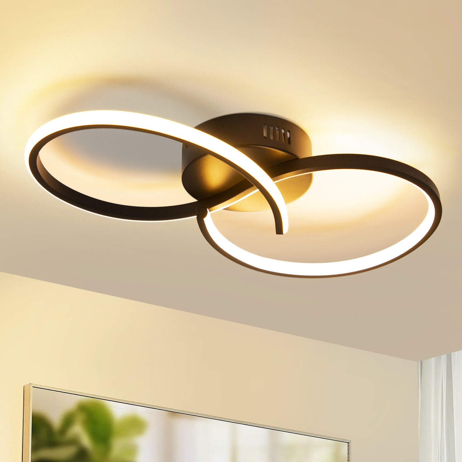 Nowoczesna lampa sufitowa z dwoma zakrzywionymi, podświetlanymi pierścieniami.