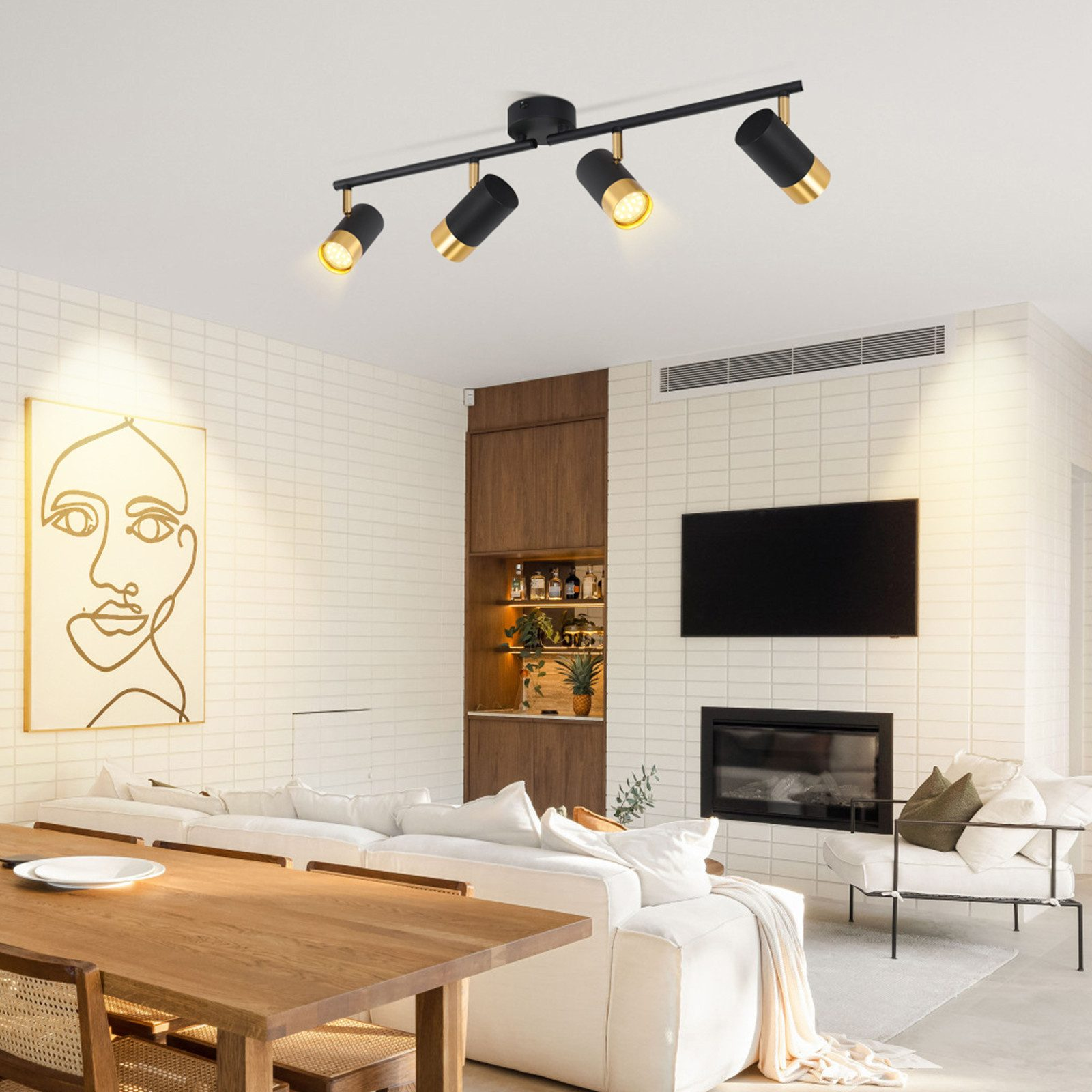Faretti da soffitto con finiture nere e oro, illuminano un moderno soggiorno.