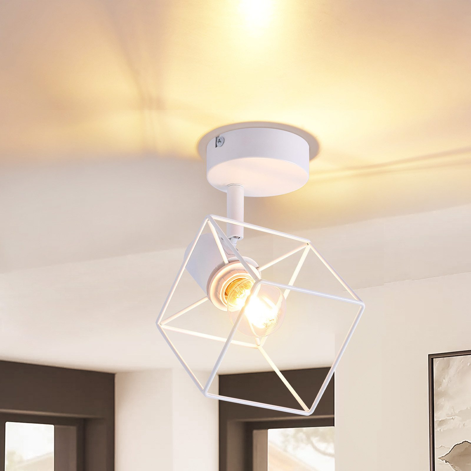Lampada da soffitto bianca con una struttura geometrica in filo metallico. La luce è accesa.