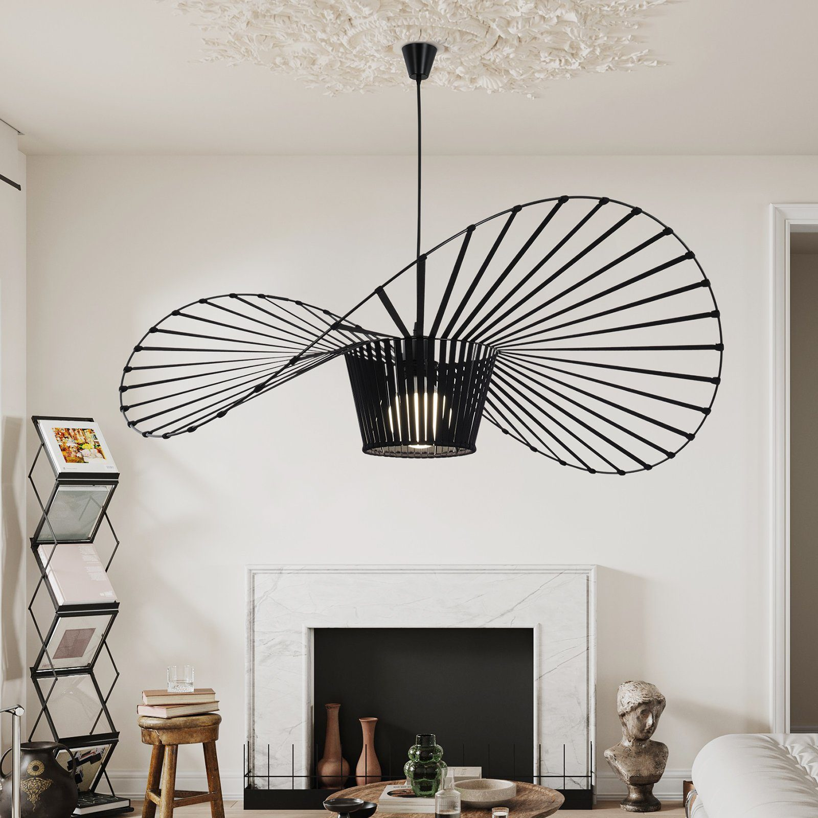 Schwarze, skulpturale Pendelleuchte über dem Kamin. Dekorative Deckendetails, Kunst und Bücher sind zu sehen.
