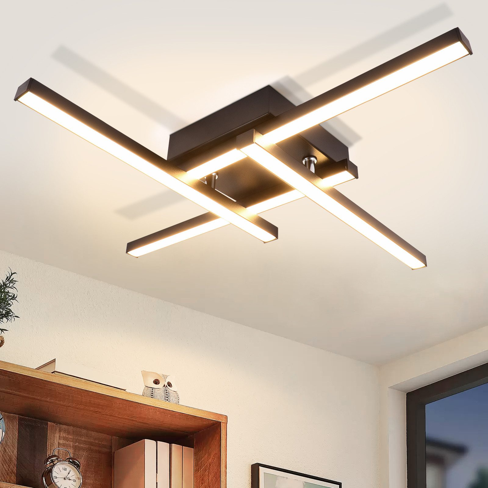 Un apparecchio di illuminazione a soffitto nero con quattro barre luminose intersecanti.