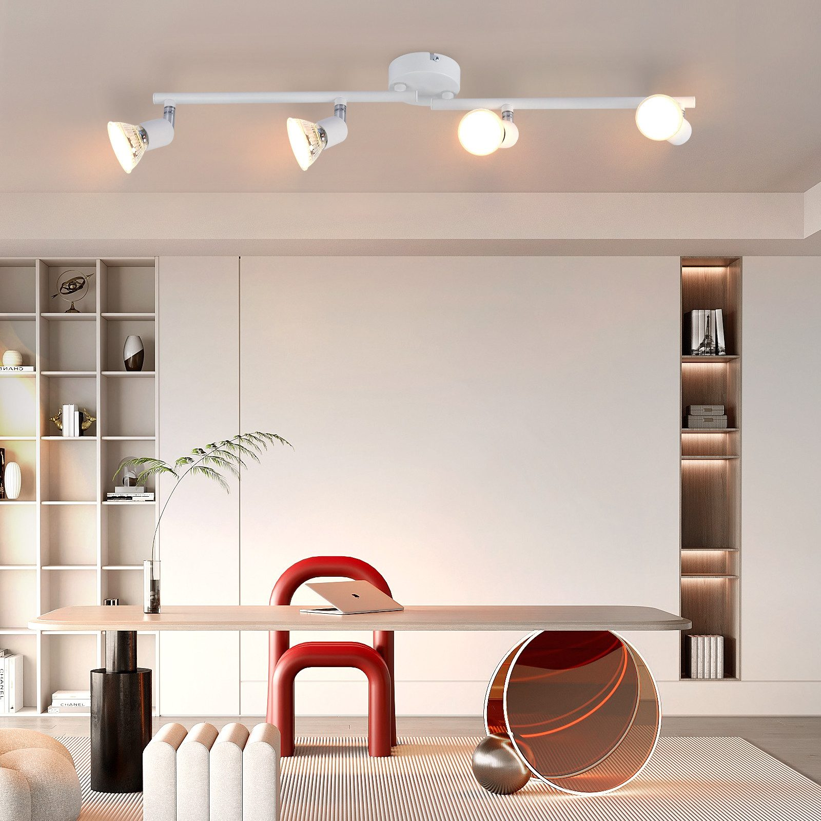 Una stanza luminosa a tema bianco con una scrivania. Ci sono quattro faretti sul soffitto e una sedia rossa.