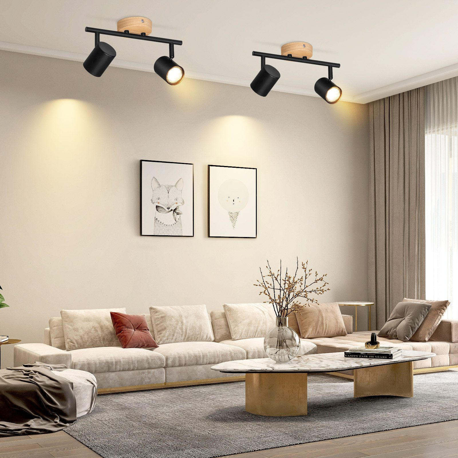 Dwa czarne reflektory sufitowe z drewnianymi akcentami oświetlają salon z kremową sofą i dziełami sztuki.