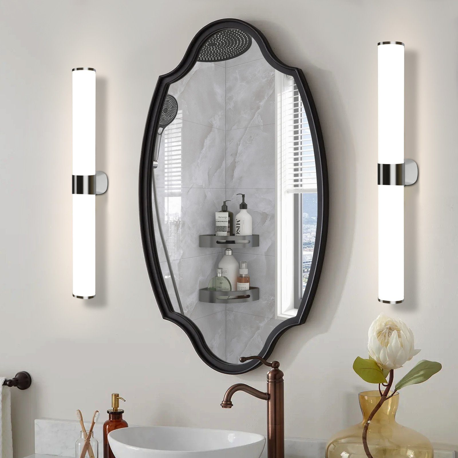 Specchio del bagno con due luci su ogni lato. Lo specchio è nero e incorniciato. Rubinetto e decorazioni presenti.