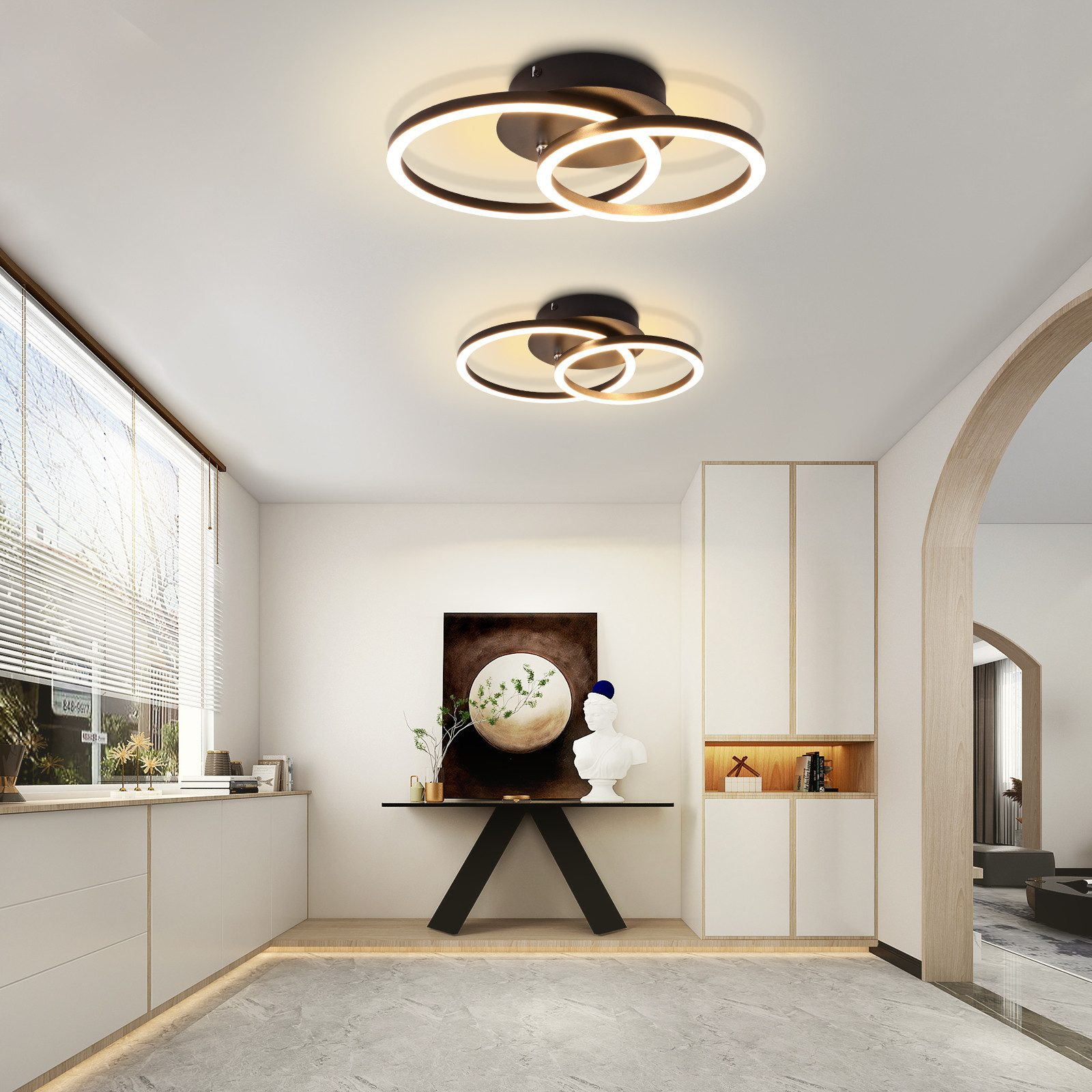 Due moderne plafoniere dal design minimalista in una stanza bianca con pavimento in marmo.