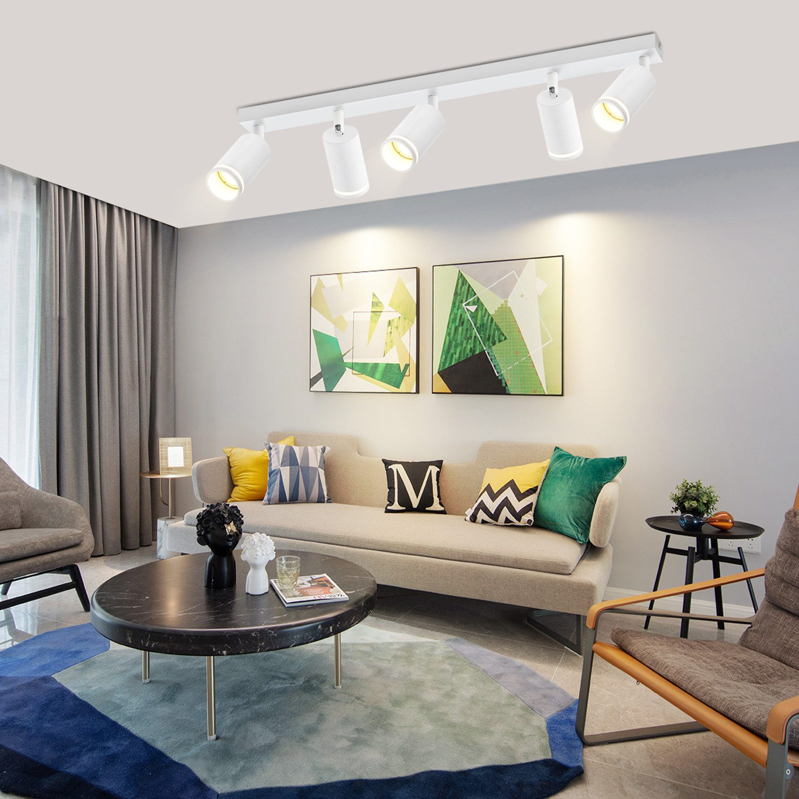 Salon z sofą, dywanem i lampą sufitową z trzema reflektorami.