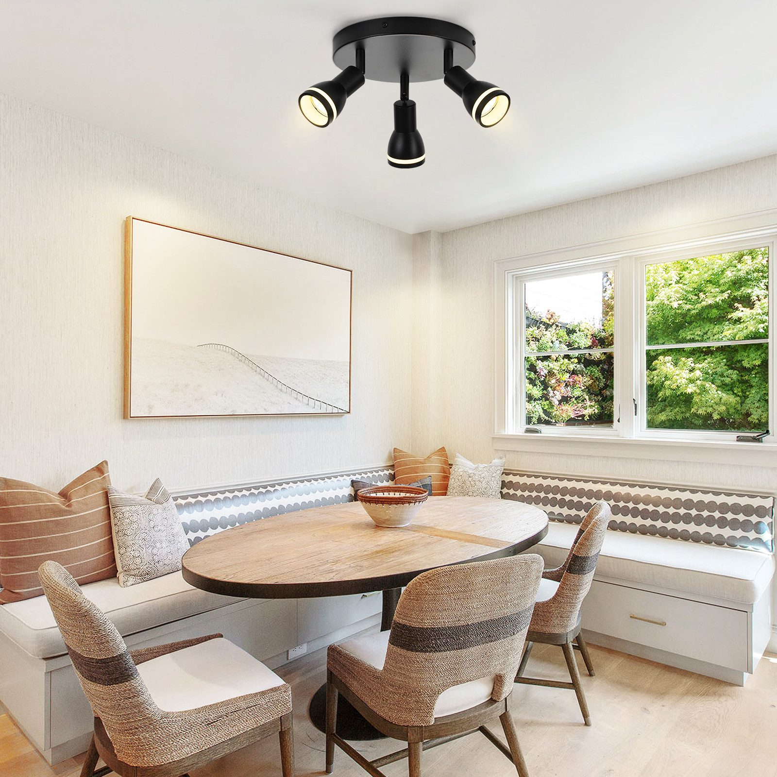 Lampada da soffitto con tre faretti, sopra un tavolo, interno stanza luminosa.