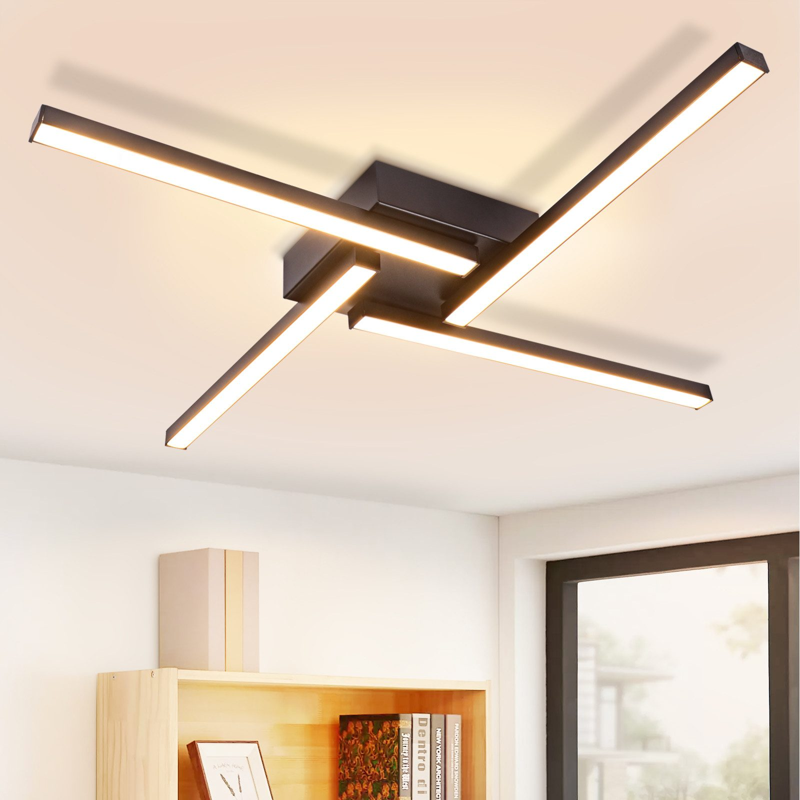 Una moderna plafoniera con quattro lunghe barre luminose che formano una croce, illuminando una stanza.