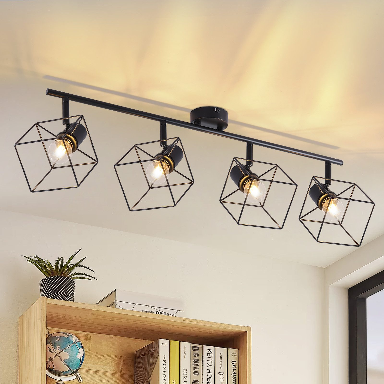 Soffitto con quattro faretti neri a forma di cubo e una mensola in legno sottostante.
