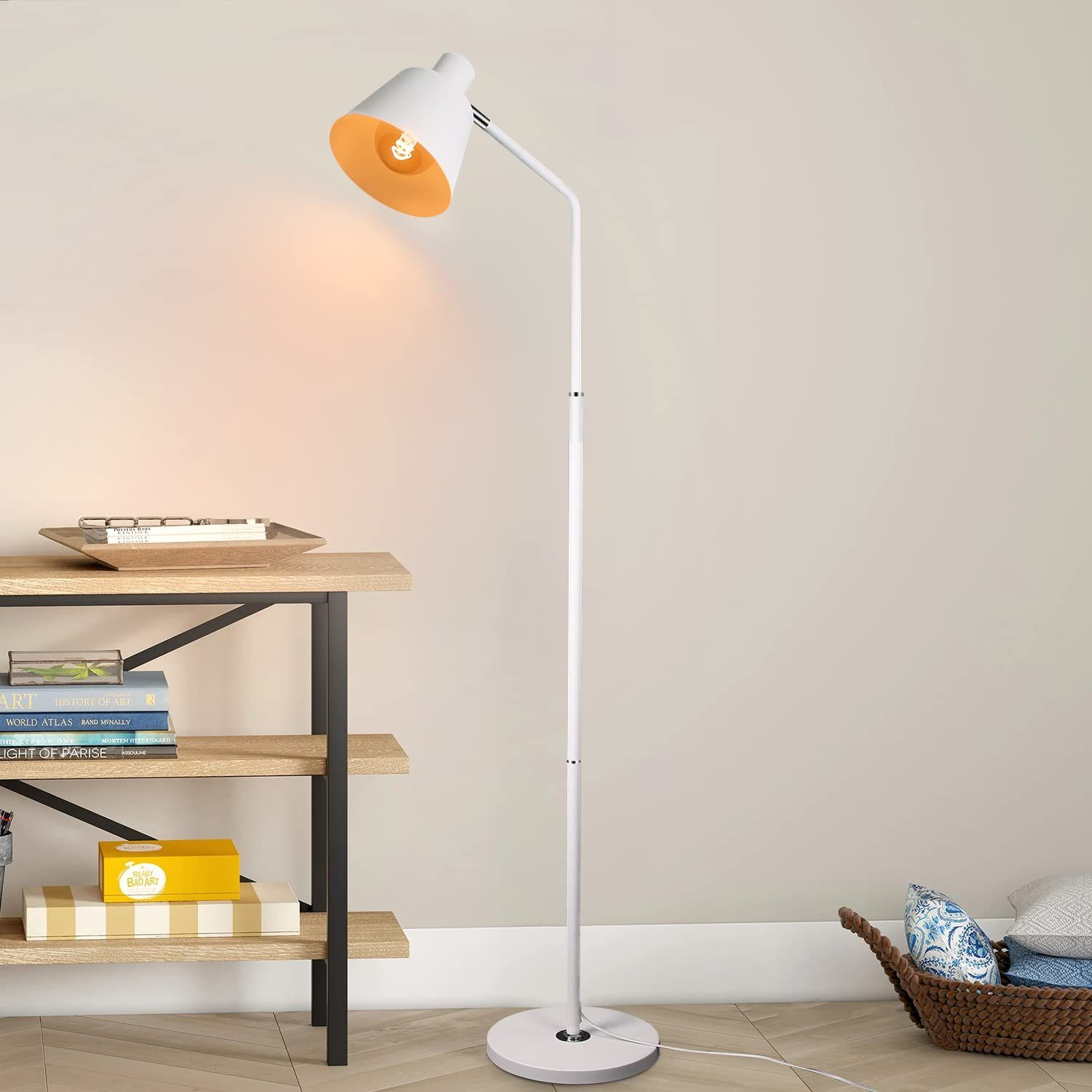 Eine Stehlampe mit weißem Stiel und einem Licht über einem Regal und einem Korb.