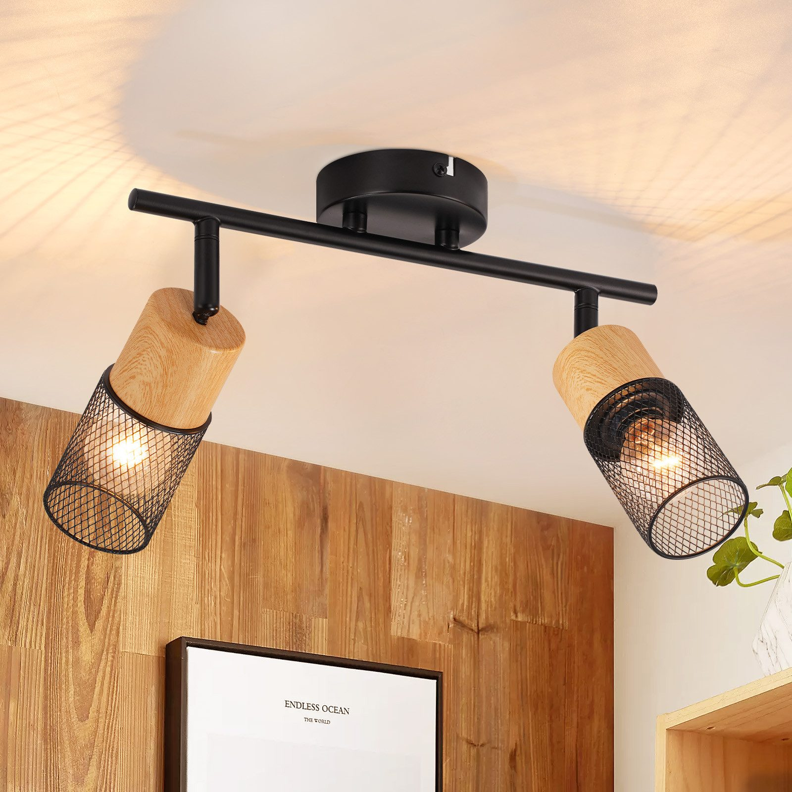 Lampade a soffitto con dettagli in legno e neri, con due luci rivolte verso il basso. Parete in legno dietro.