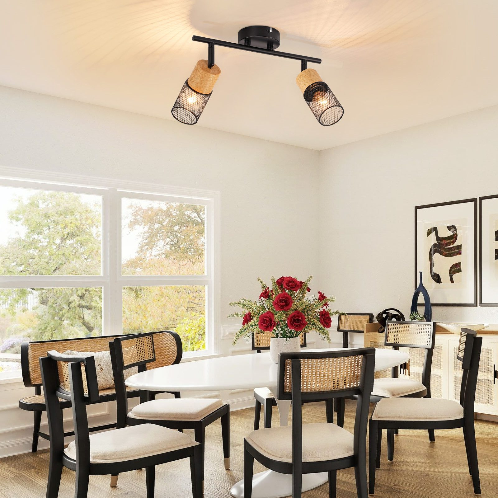 Jadalnia z owalnym stołem, krzesłami, kwiatami i nowoczesną lampą.