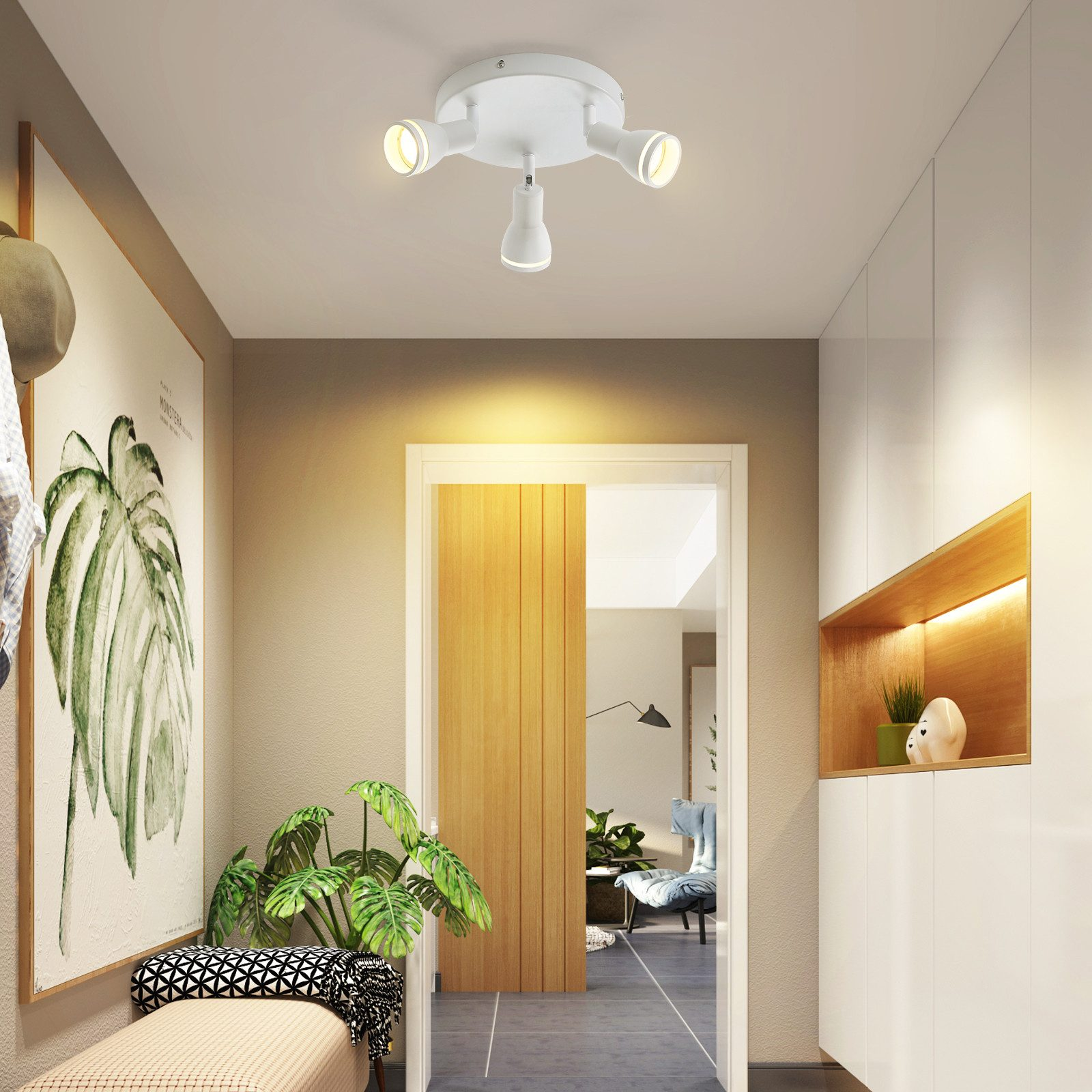 Corridoio con tre faretti a soffitto. Dipinto a sinistra, porta e armadi sullo sfondo.