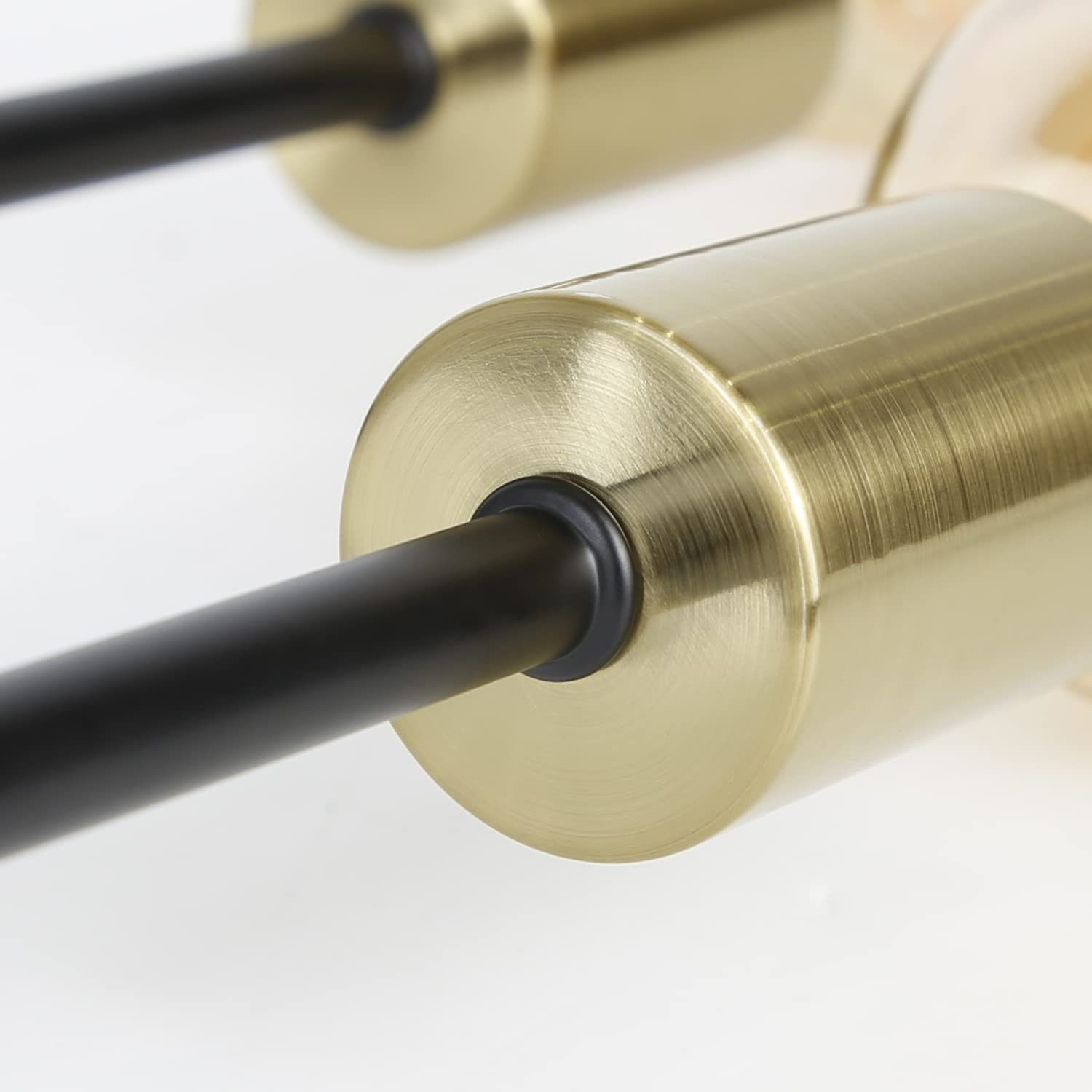 Zbliżenie złotego reflektora, ujawniające źródło światła i trzon. Czarny cylindryczny korpus.