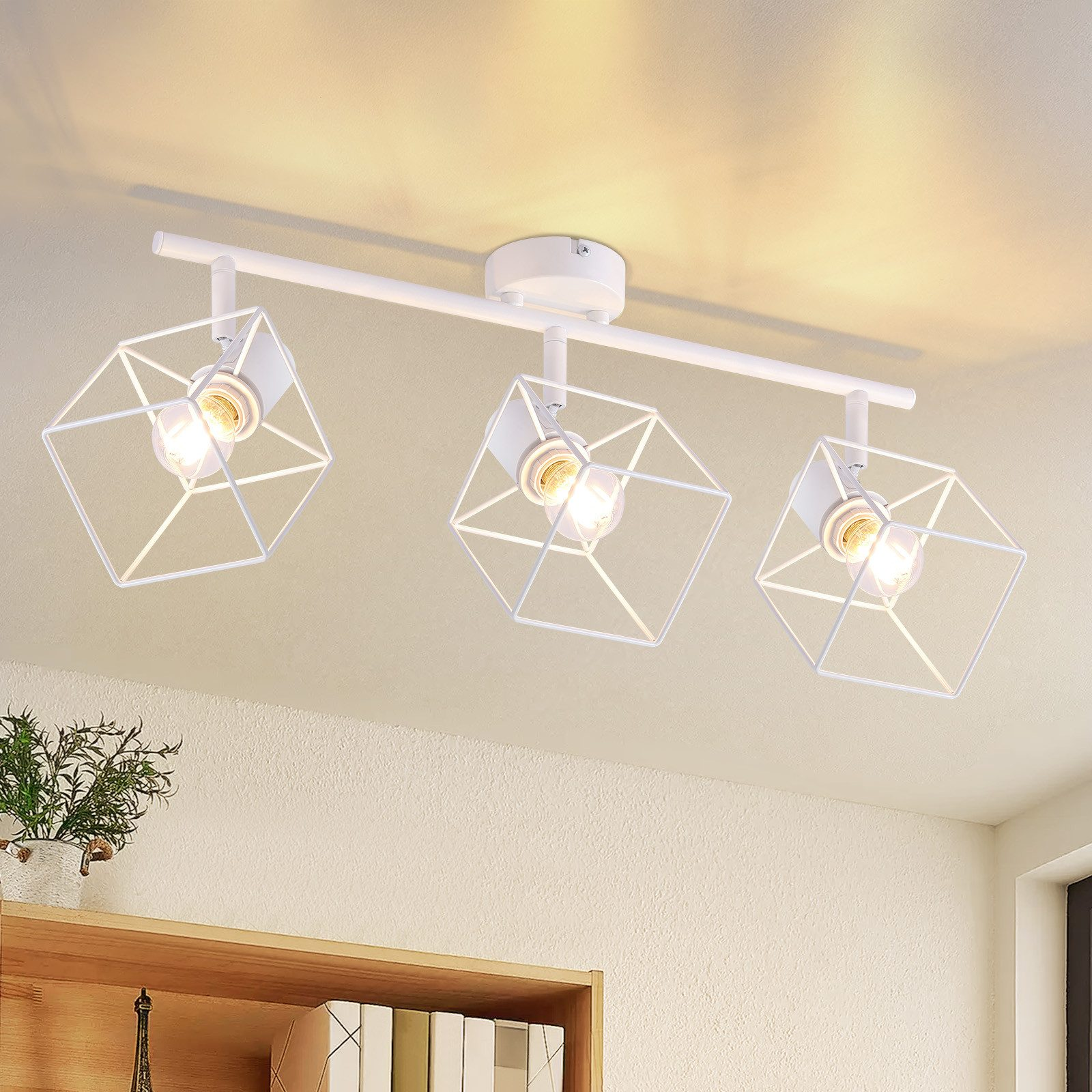 Lampada da soffitto bianca con tre paralumi geometrici a gabbia.
