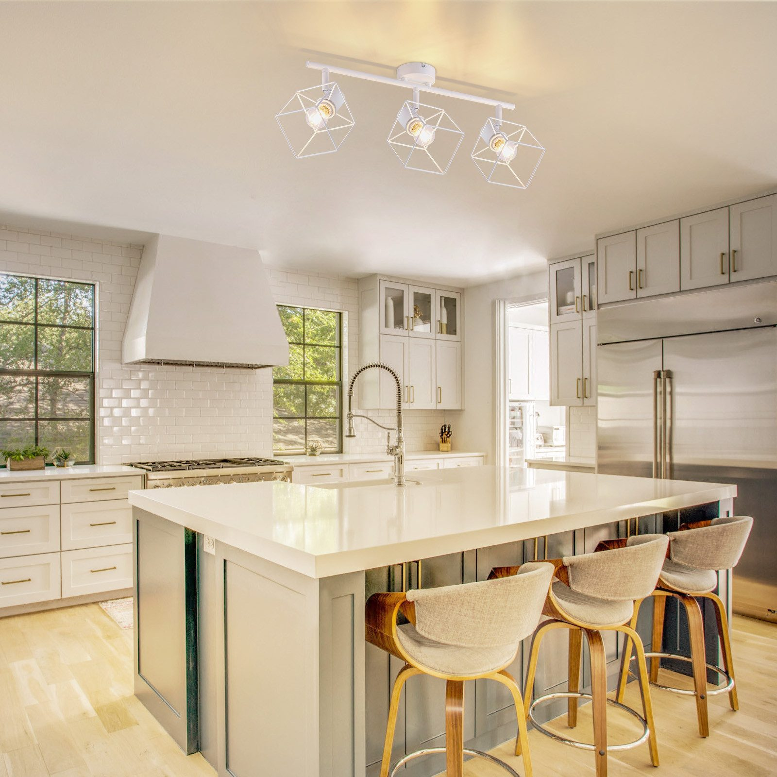 Una cucina moderna con un'isola bianca e apparecchi di illuminazione bianchi.
