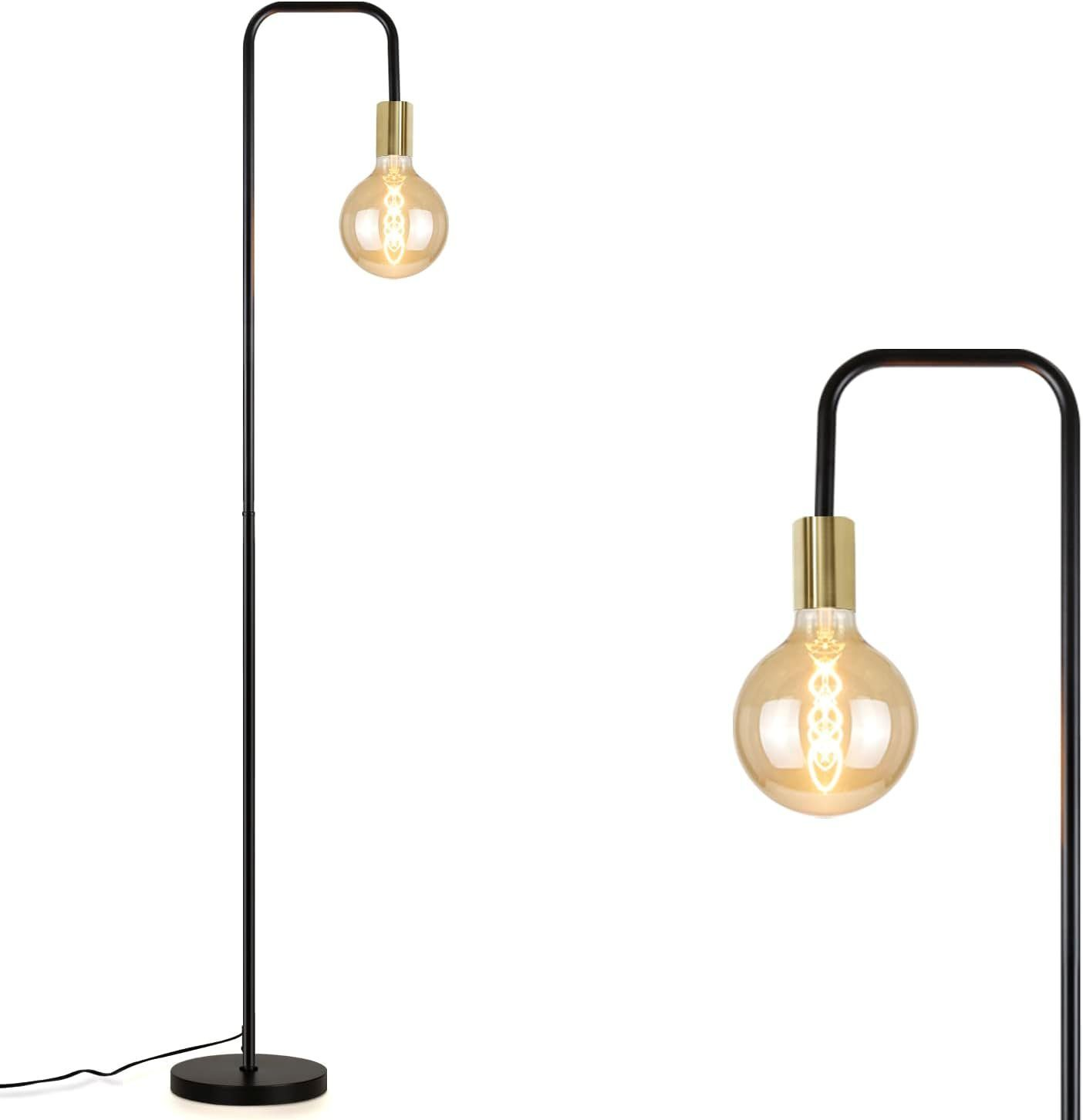 Una lampada da terra nera e oro con una grande lampadina rotonda. La lampada è su sfondo bianco.