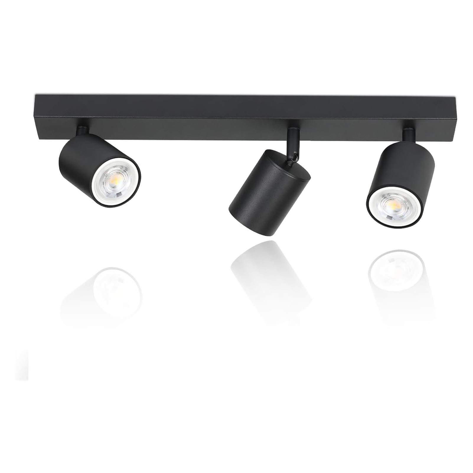 Czarna lampa szynowa z trzema regulowanymi światłami. Białe tło.