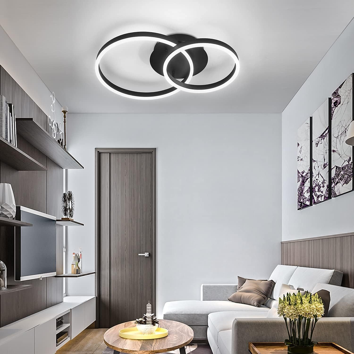 Un soggiorno moderno con un lampadario bianco e nero. Sono visibili anche un divano, una TV e una porta.