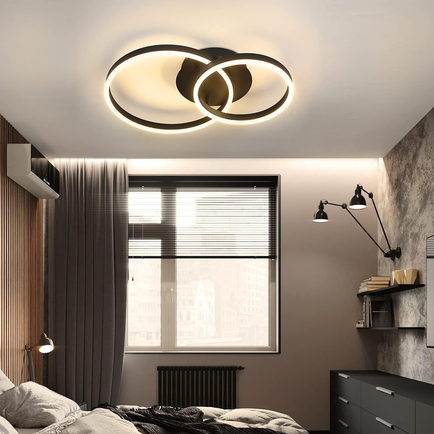 Deckenleuchte mit zwei verbundenen, leuchtenden, kreisförmigen Elementen. Schlafzimmer mit Bett und Fenster.