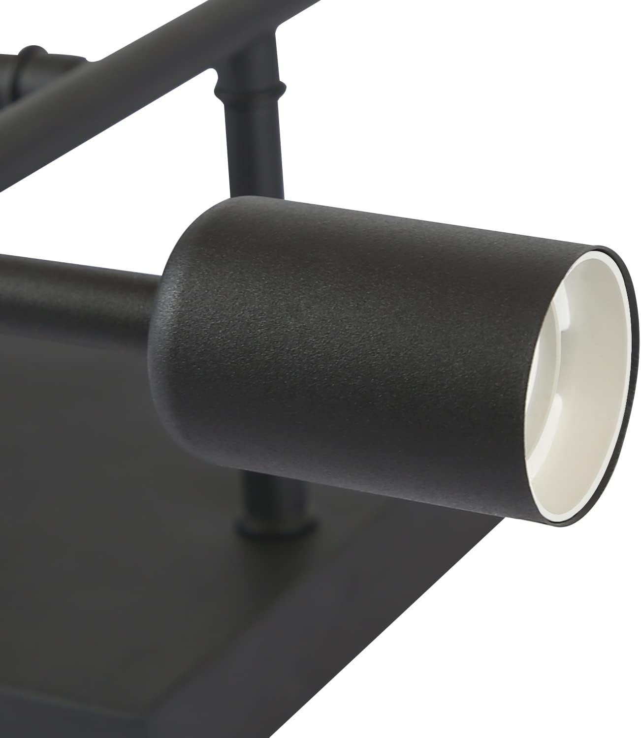 Primo piano di un apparecchio di illuminazione nero, cilindrico con interno bianco, montato su base nera.