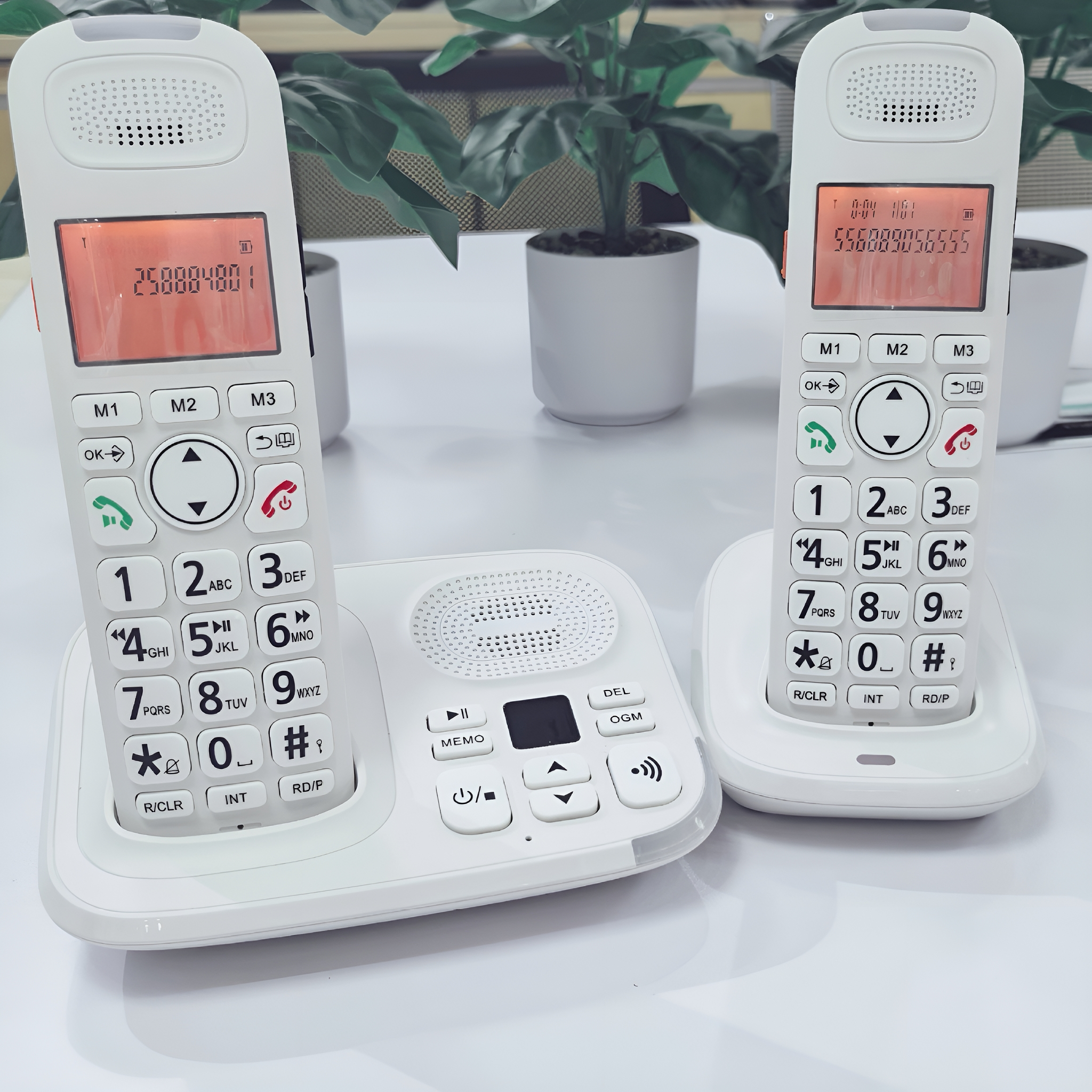 Weiße schnurlose Telefone mit Zifferntasten und Displays. Basis und zwei Handapparate.