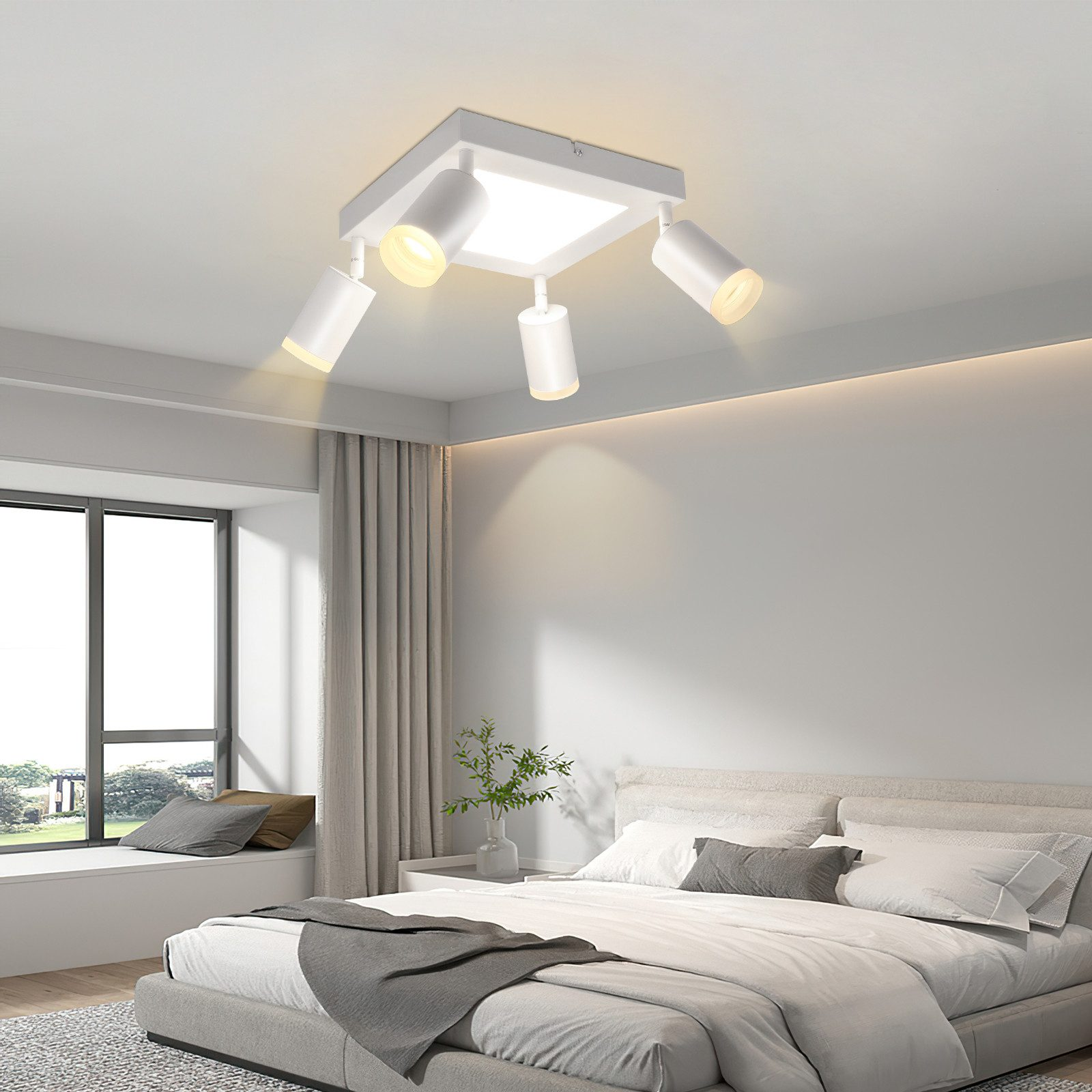 Un apparecchio di illuminazione a soffitto bianco con quattro faretti orientabili, in una camera da letto.