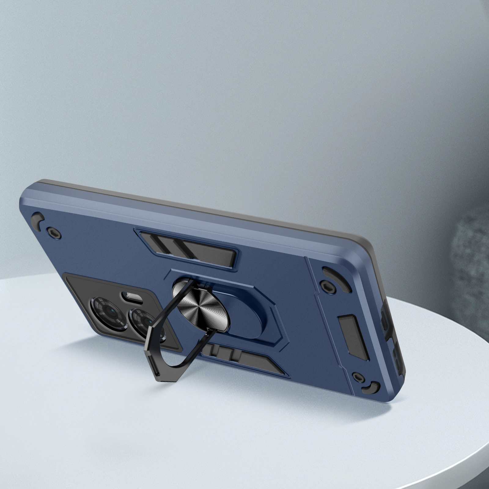 Una custodia per telefono blu con un supporto ad anello nero, appoggiata su una superficie chiara, con sfondo.
