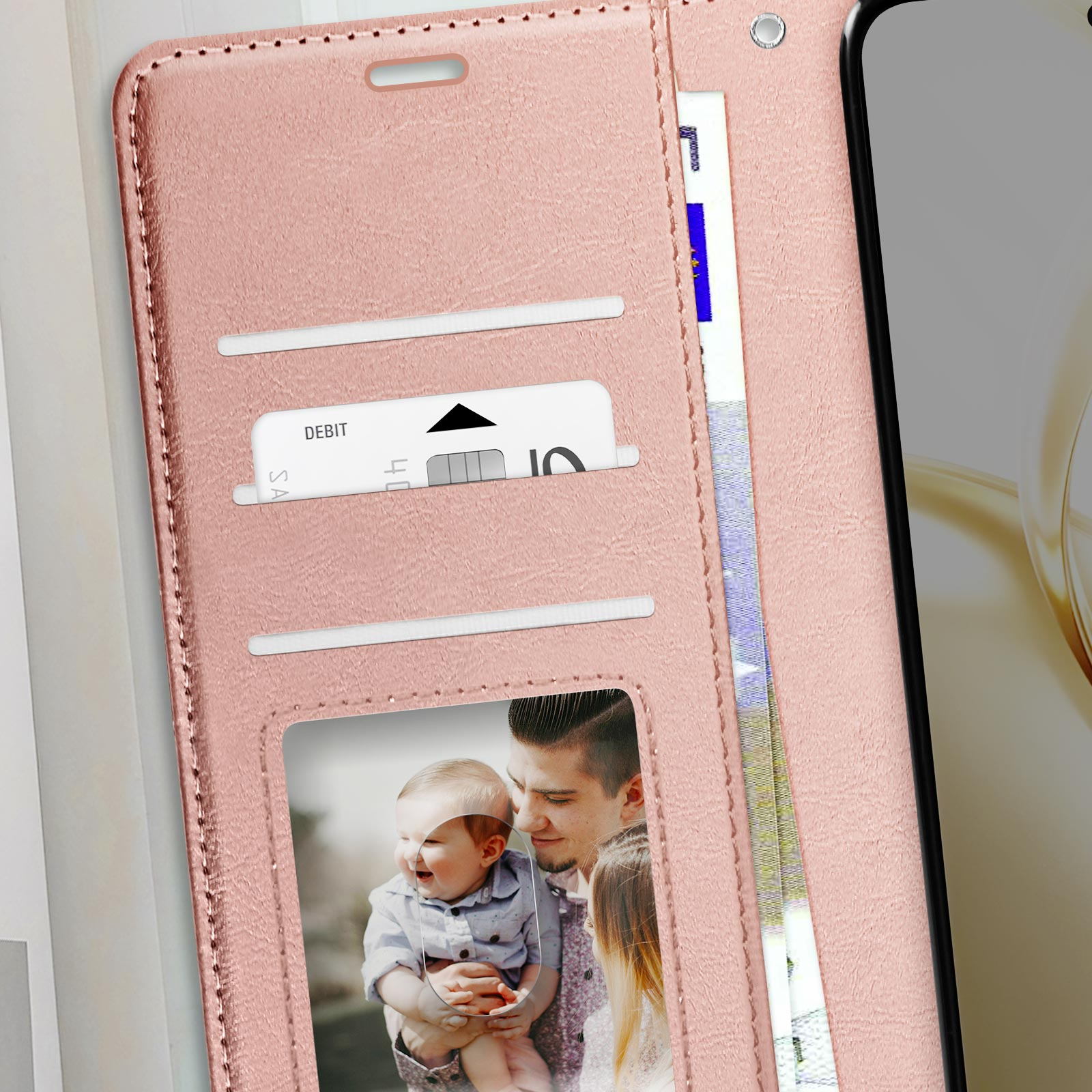 Custodia a portafoglio rosa per telefono con carta e foto di famiglia. La custodia è aperta.