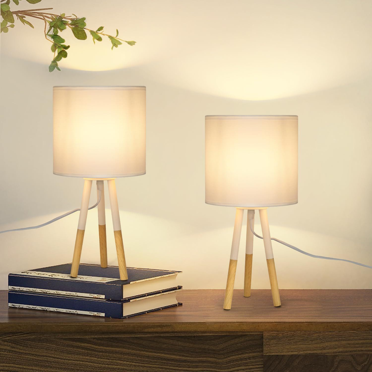 Dwie małe lampy stołowe z białymi kloszami na drewnianej powierzchni.