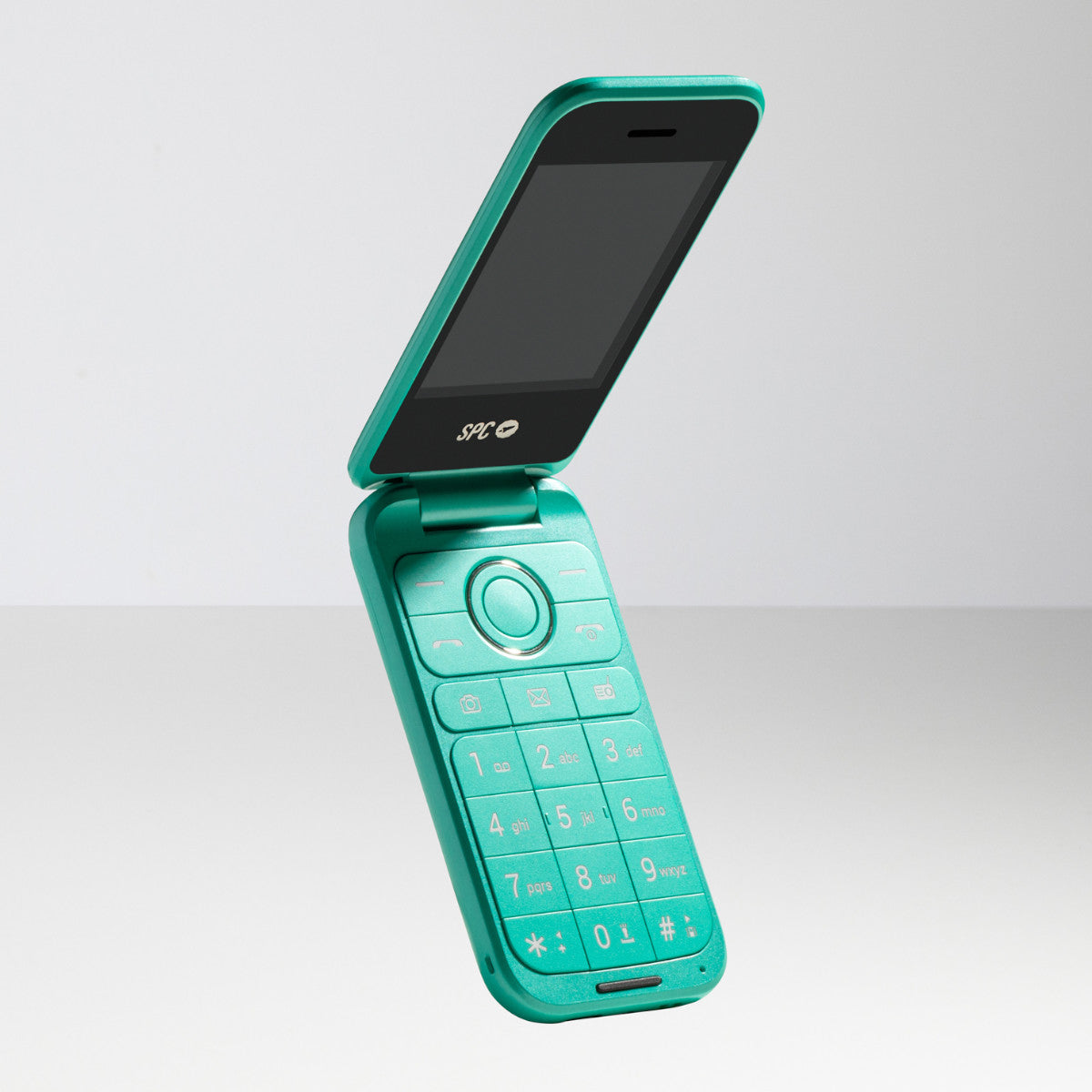 Turkusowy telefon z klapką otwarty, pokazujący ekran i klawiaturę. Na białej powierzchni.