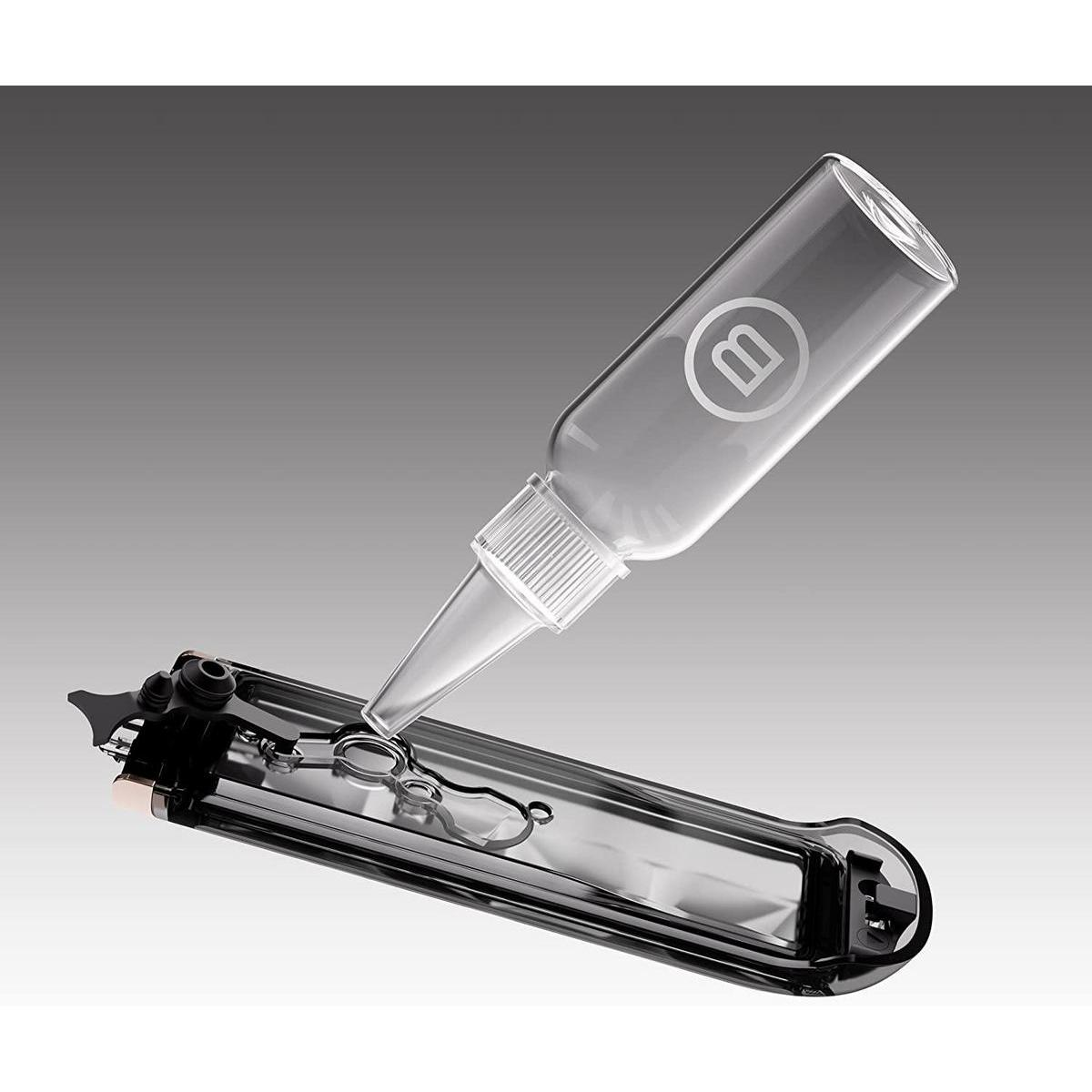 Butelka wylewająca płyn na czarne urządzenie. Tło to szary gradient.