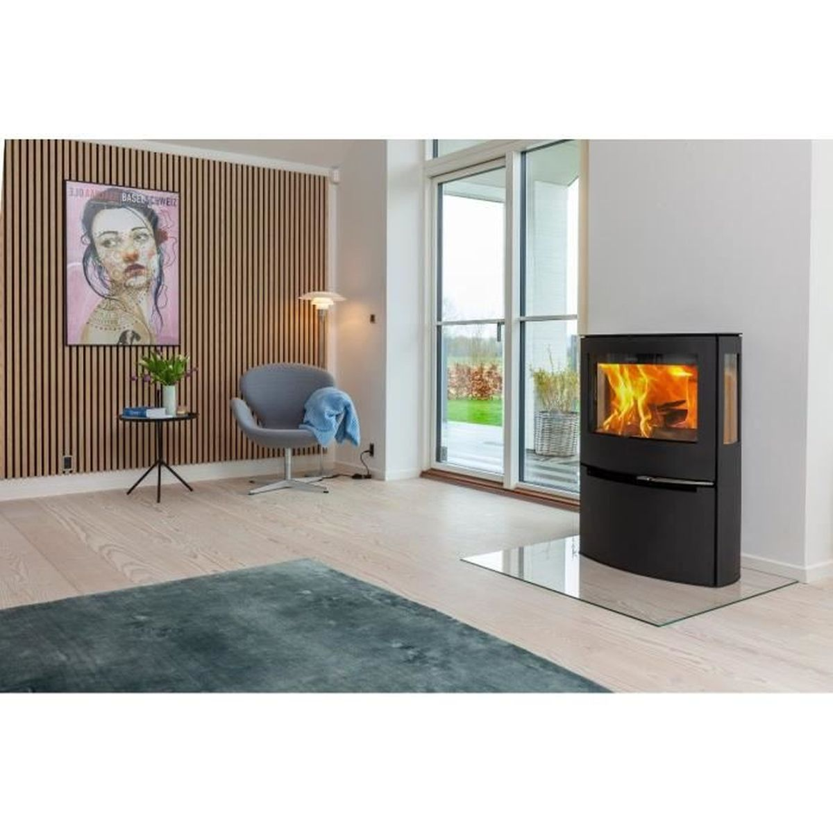 Wohnzimmer mit Kamin, Stuhl, Gemälde und Teppich.
