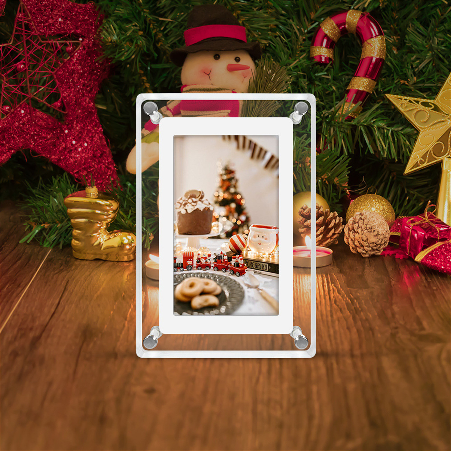 Ein gerahmtes Bild mit einer Weihnachtsszene. Ein Schneemann, Ornamente und eine Zuckerstange sind im Hintergrund sichtbar.
