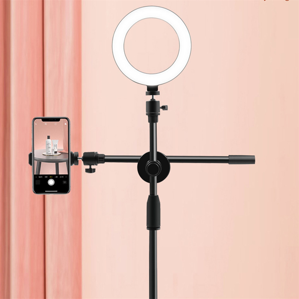 Ein Ringlicht mit angebrachtem Telefon vor pinkfarbenem Hintergrund.