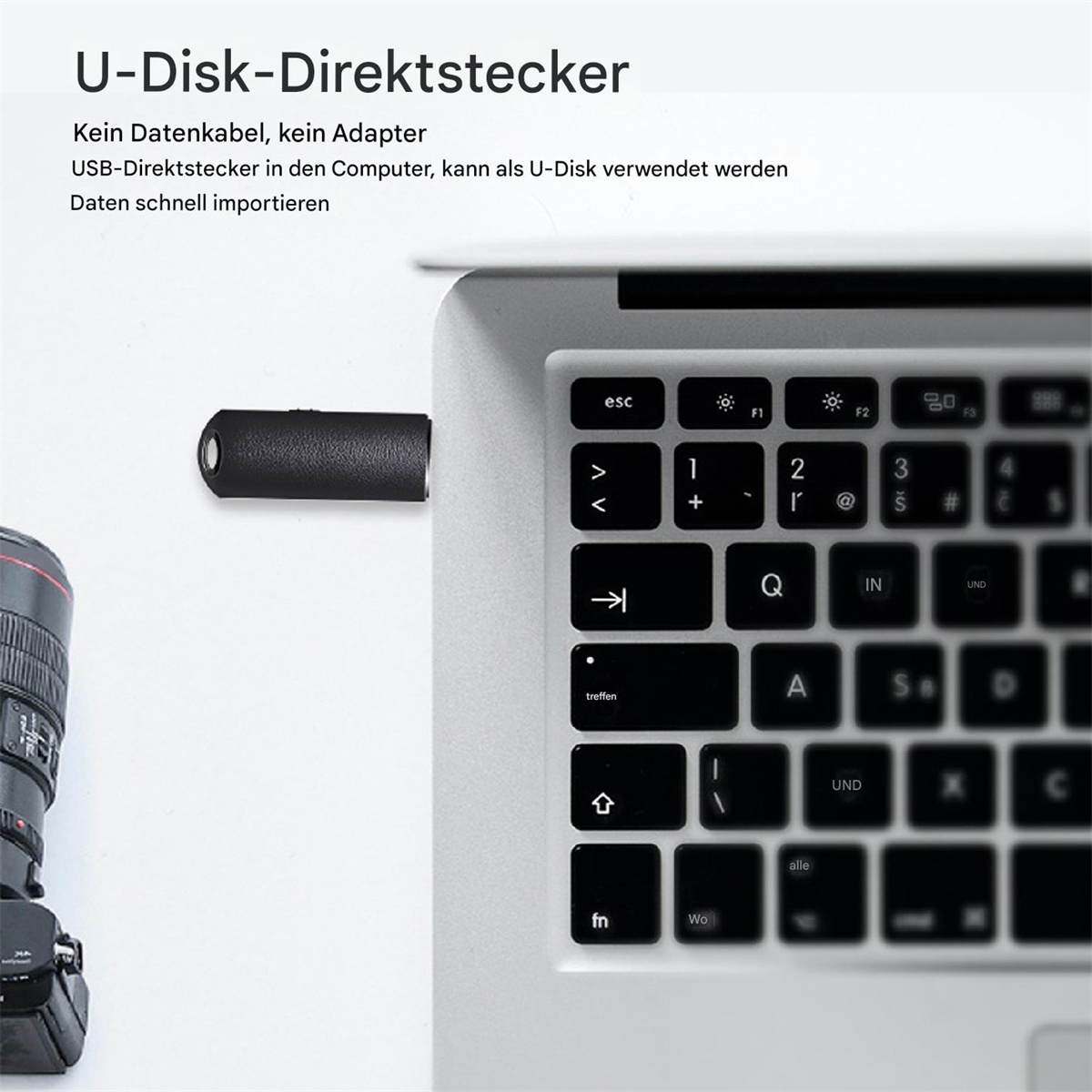 Laptop-Tastatur mit eingestecktem USB-Direktstecker. Eine Kamera ist im Hintergrund.
