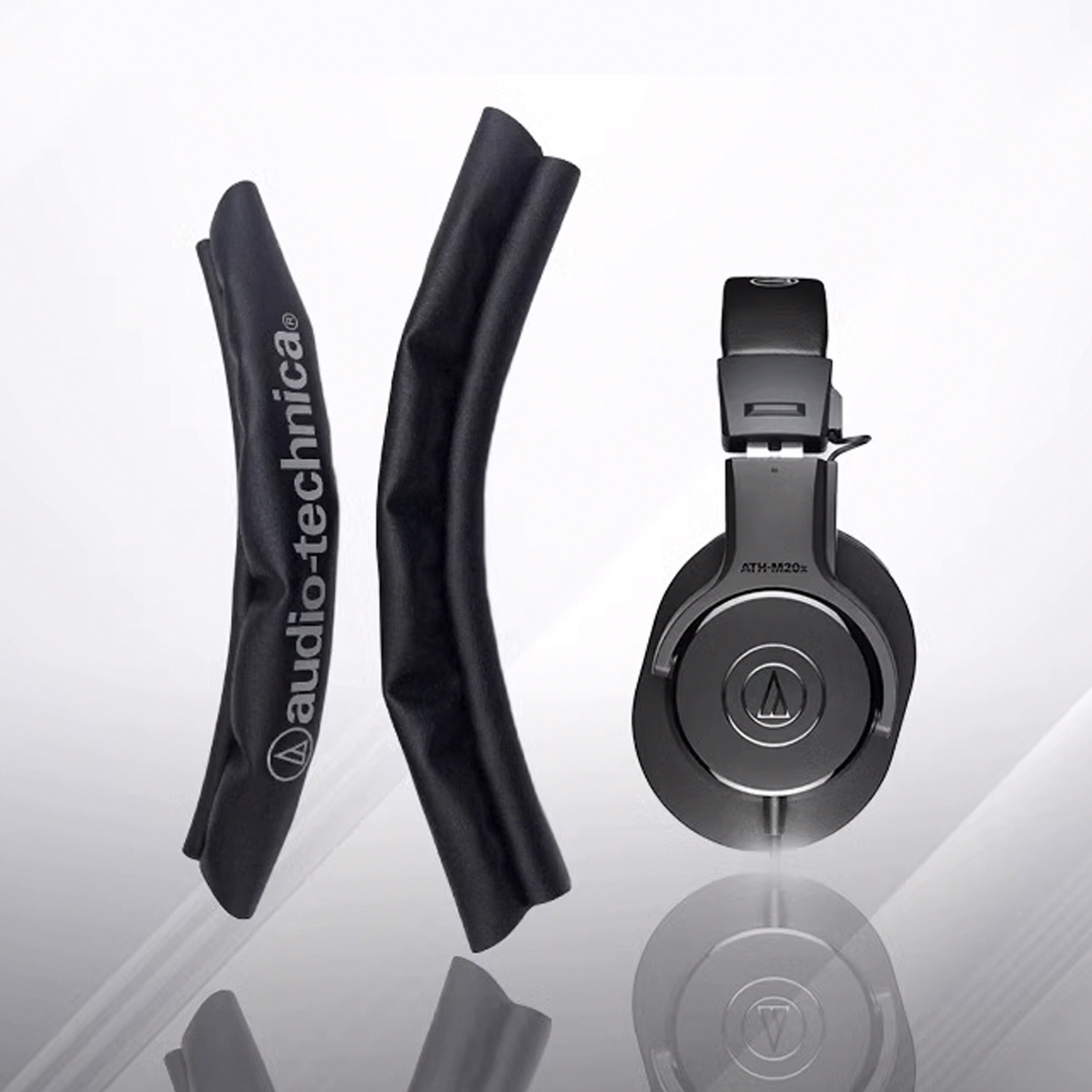 Zwarte koptelefoon met oorkussens en beschermhoezen. Merk: Audio-Technica.