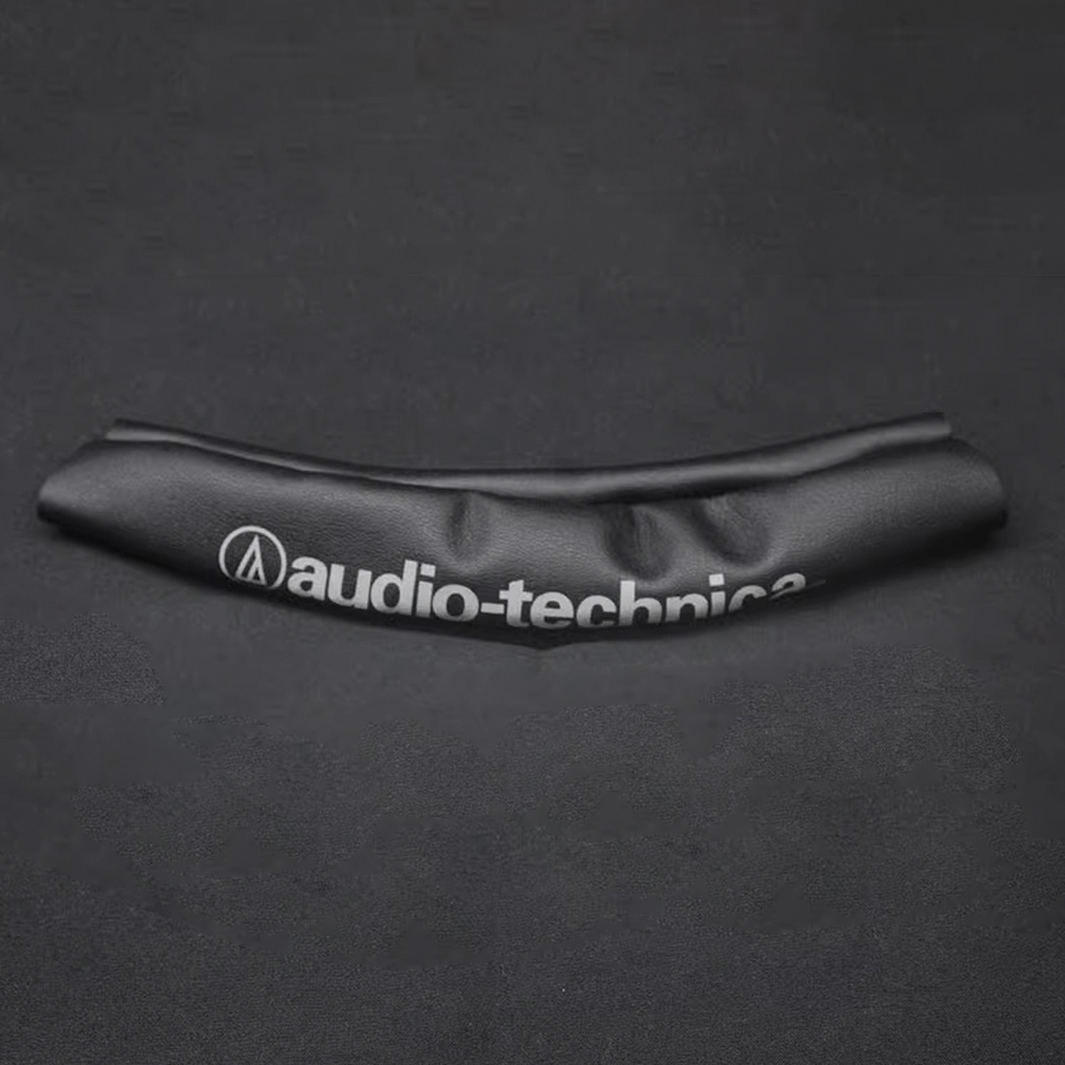 Zwarte hoofdband met witte tekst. De tekst luidt audio-technica.