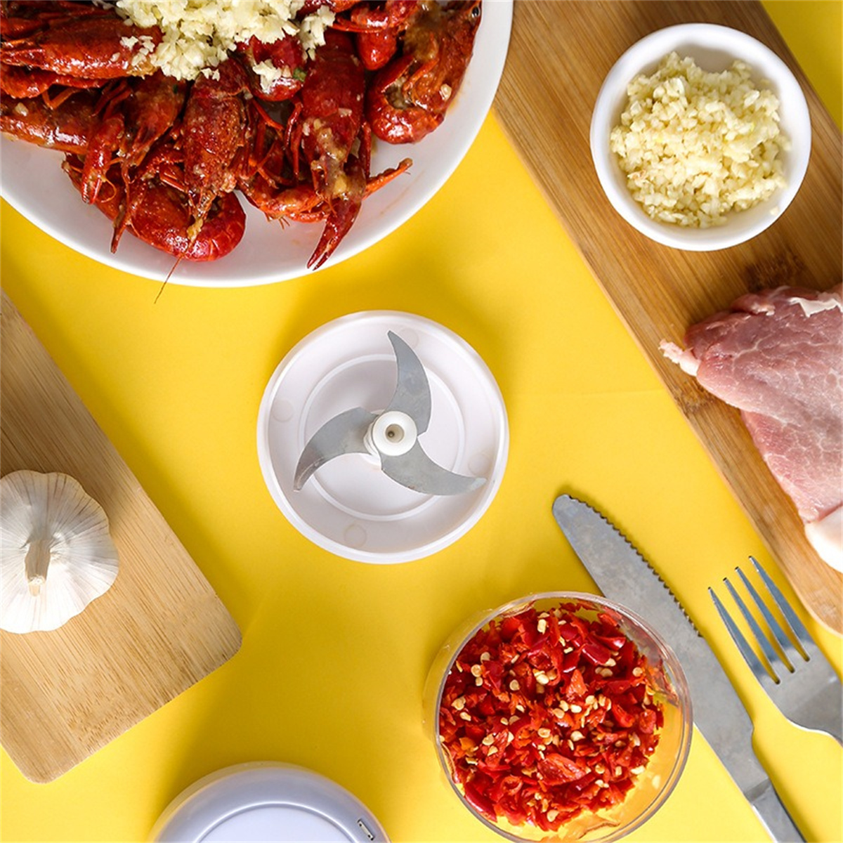 Draufsicht auf die Essenszubereitung. Enthält Krebse, Knoblauch, einen Zerkleinerer, Knoblauch, Fleisch und Chilischoten.
