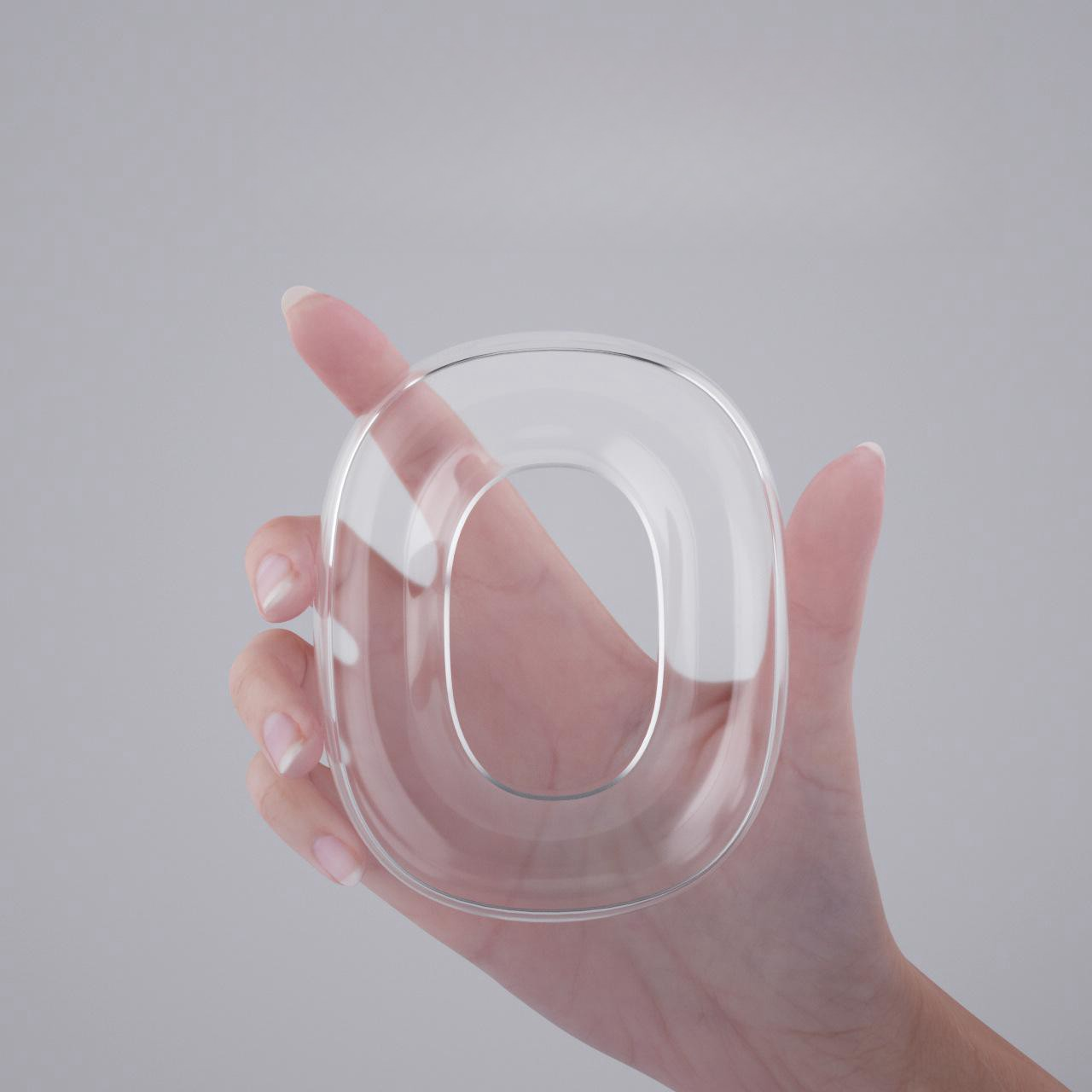 Dłoń trzymająca przezroczysty, przezroczysty, szklany obiekt w kształcie litery O.